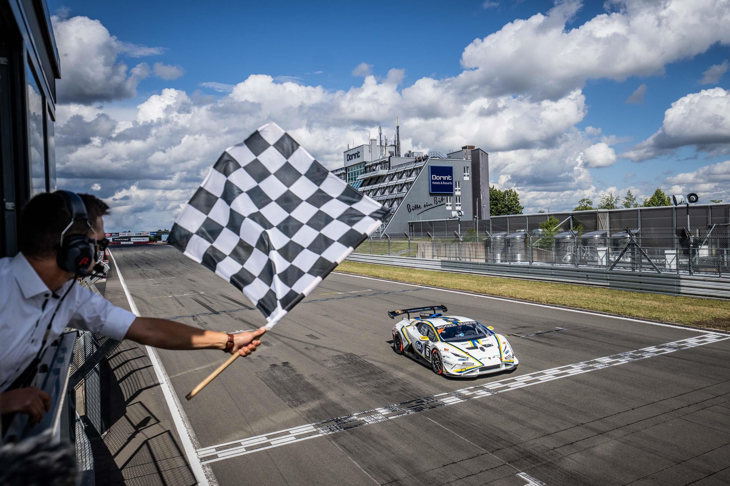 A 17-Year-Old Egyptian Just Rewrote The Record Books At Nürburgring'S Super Trofeo Europe Round 3 A white lamborghini huracán super trofeo evo2 crosses the finish line at the nürburgring as a race official waves the checkered flag