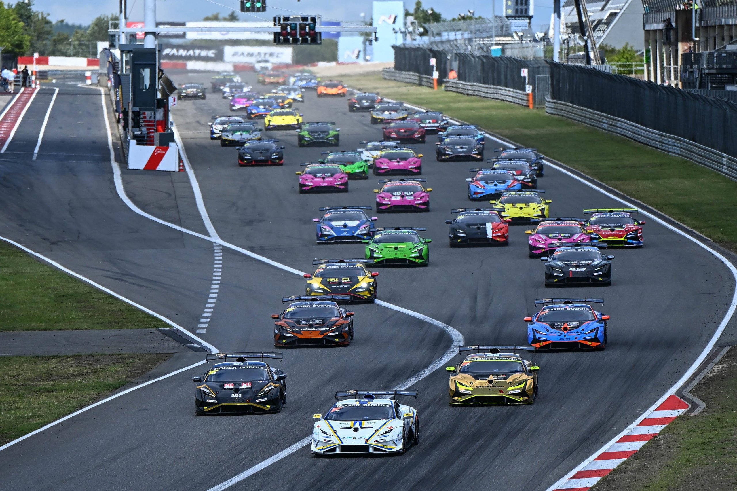 A 17-Year-Old Egyptian Just Rewrote The Record Books At Nürburgring'S Super Trofeo Europe Round 13 A full grid of lamborghini huracán super trofeo evo2 race cars in diverse liveries navigating a turn during the nürburgring round