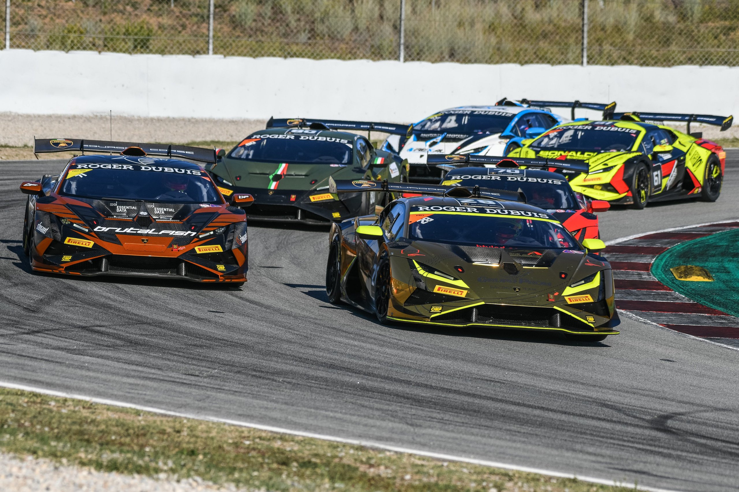 How Bonaldi Motorsport Turned A Botched Rival Pit Stop Into A Barcelona Title Sweep 5 A pack of lamborghini huracán super trofeo evo2 race cars in various liveries navigate a turn on the barcelona circuit