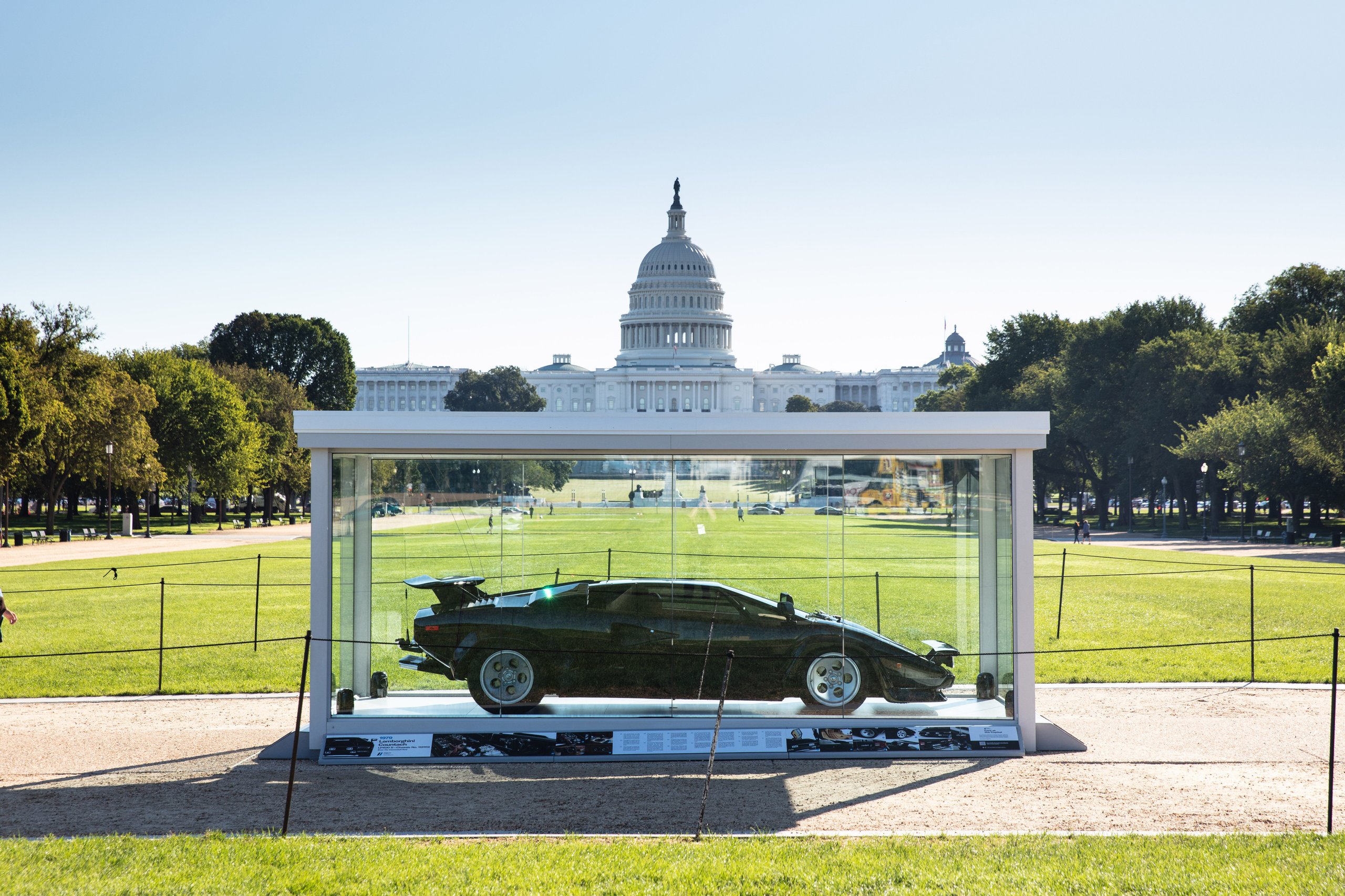 The 'Cannonball Run' Countach Now Sits On The National Mall, Officially One Of America'S Most Important Cars 3 The cannonball run lamborghini countach lp 400 s displayed in a glass case on a sunny day with the us capitol building behind it