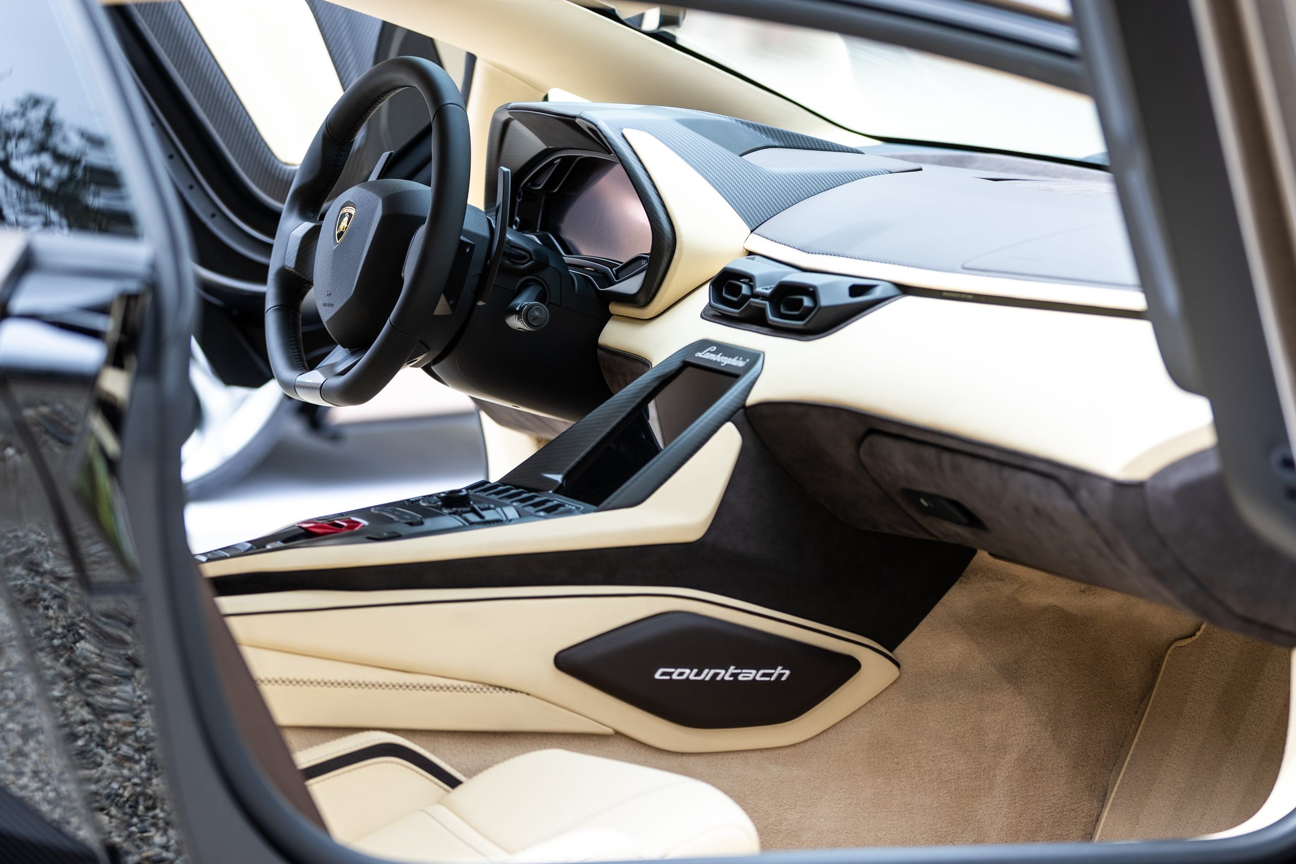 Lamborghini Handed Over Two Countach Lpi 800-4S At Monterey, And The Real Story Is What That Ceremony Signals 9 Interior of the lamborghini countach lpi 800-4 showing cream and black upholstery, digital dashboard, and hexagonal design motifs