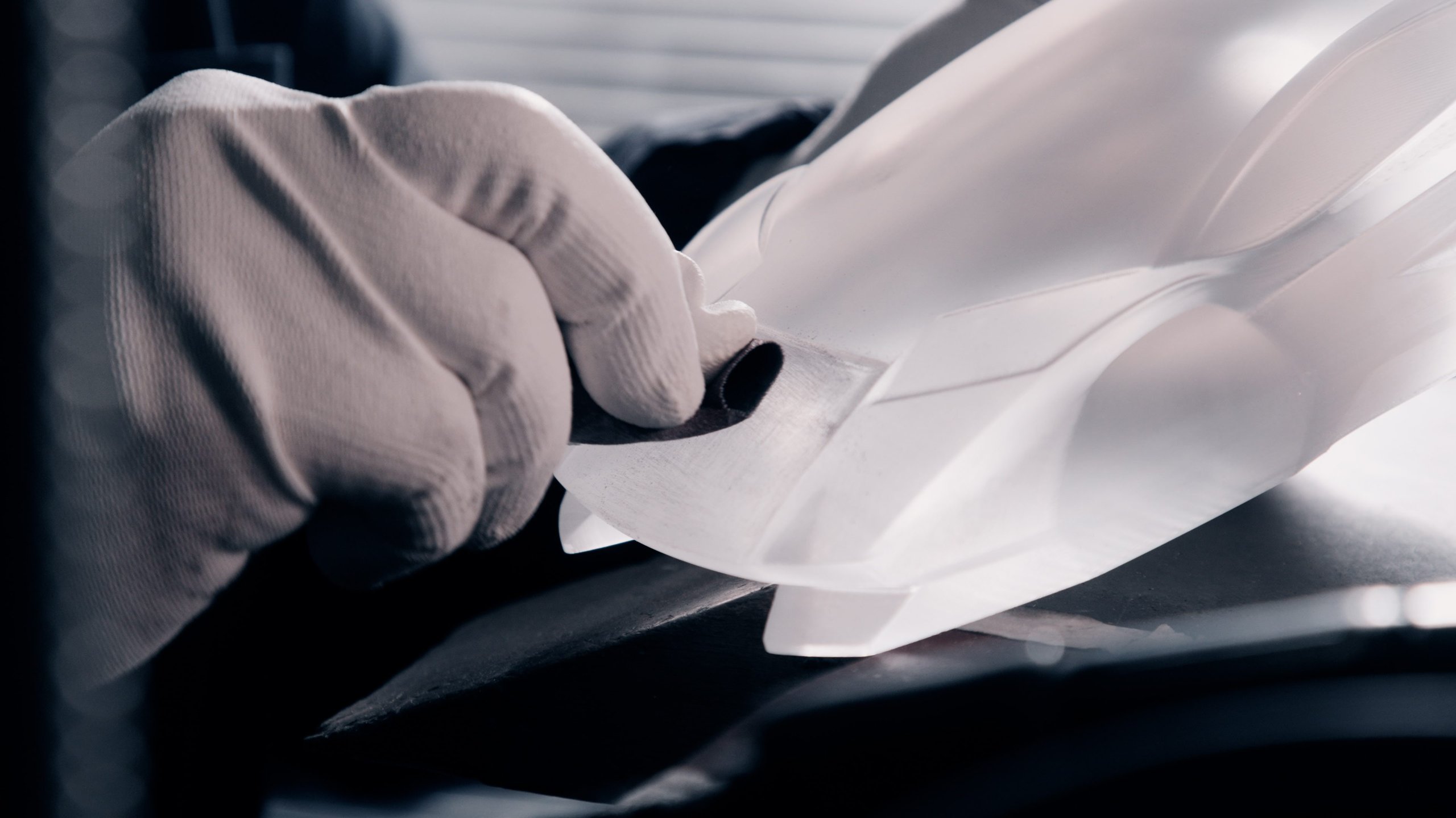 Lamborghini Turns Countach Lpi 800-4 Ownership Into A Numbered Art Collection 5 Gloved hand meticulously refining a white scale model of a lamborghini in a workshop setting