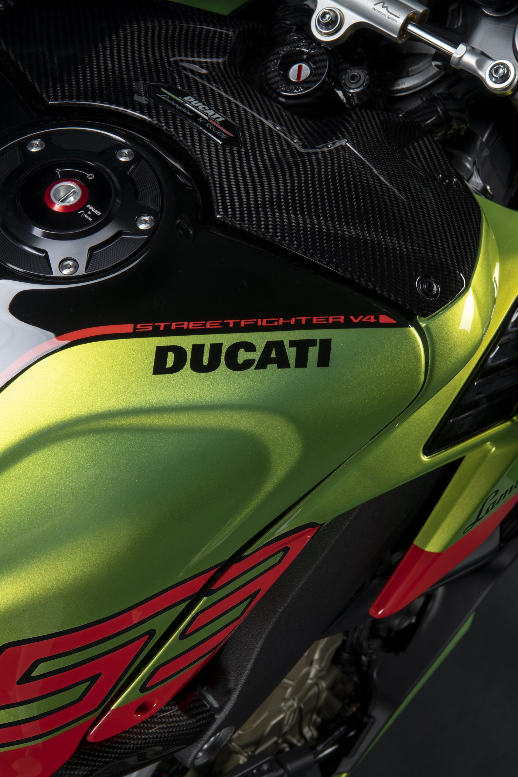 The Ducati Streetfighter V4 Lamborghini Puts The Huracán Sto In Your Garage On Two Wheels 13 Close-up of the ducati streetfighter v4 lamborghini fuel tank and carbon fiber elements showing ducati and streetfighter v4 branding
