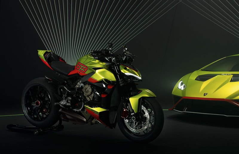 Ducati Streetfighter V4 Lamborghini motorcycle parked beside a matching Lamborghini Huracán STO in Verde Citrea green in a dark studio