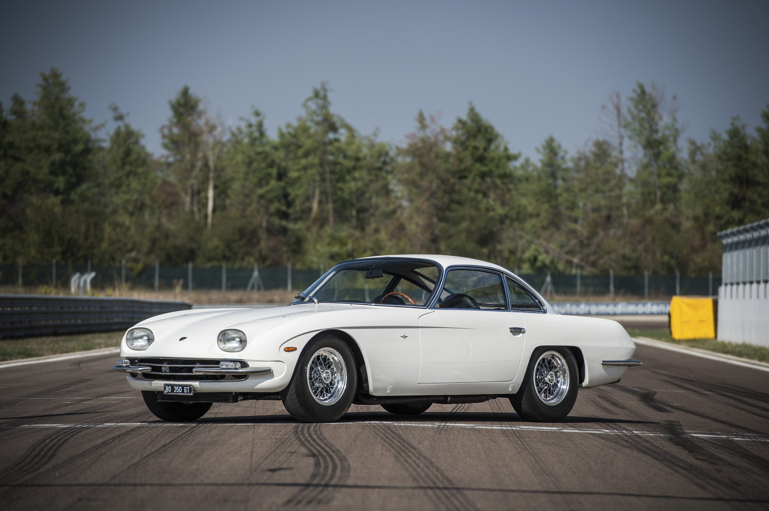 Ferruccio Lamborghini At 105: How A Stubborn Tractor Builder'S Grudge Created An Automotive Dynasty 13 A pristine white lamborghini 350 gt parked on a racetrack with tire marks on the asphalt