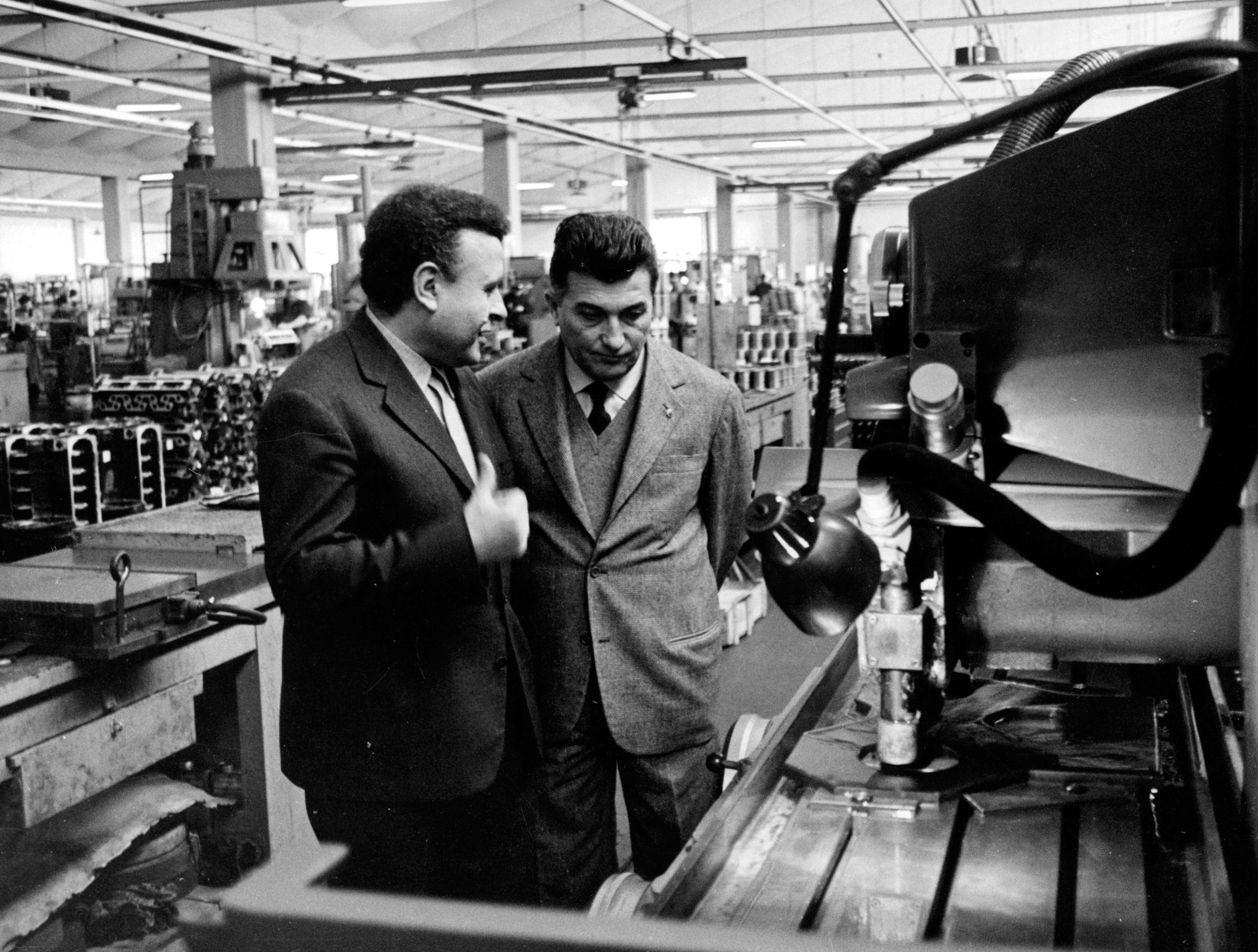 Ferruccio Lamborghini At 105: How A Stubborn Tractor Builder'S Grudge Created An Automotive Dynasty 5 Black and white image of ferruccio lamborghini and another man inspecting machinery in a factory setting