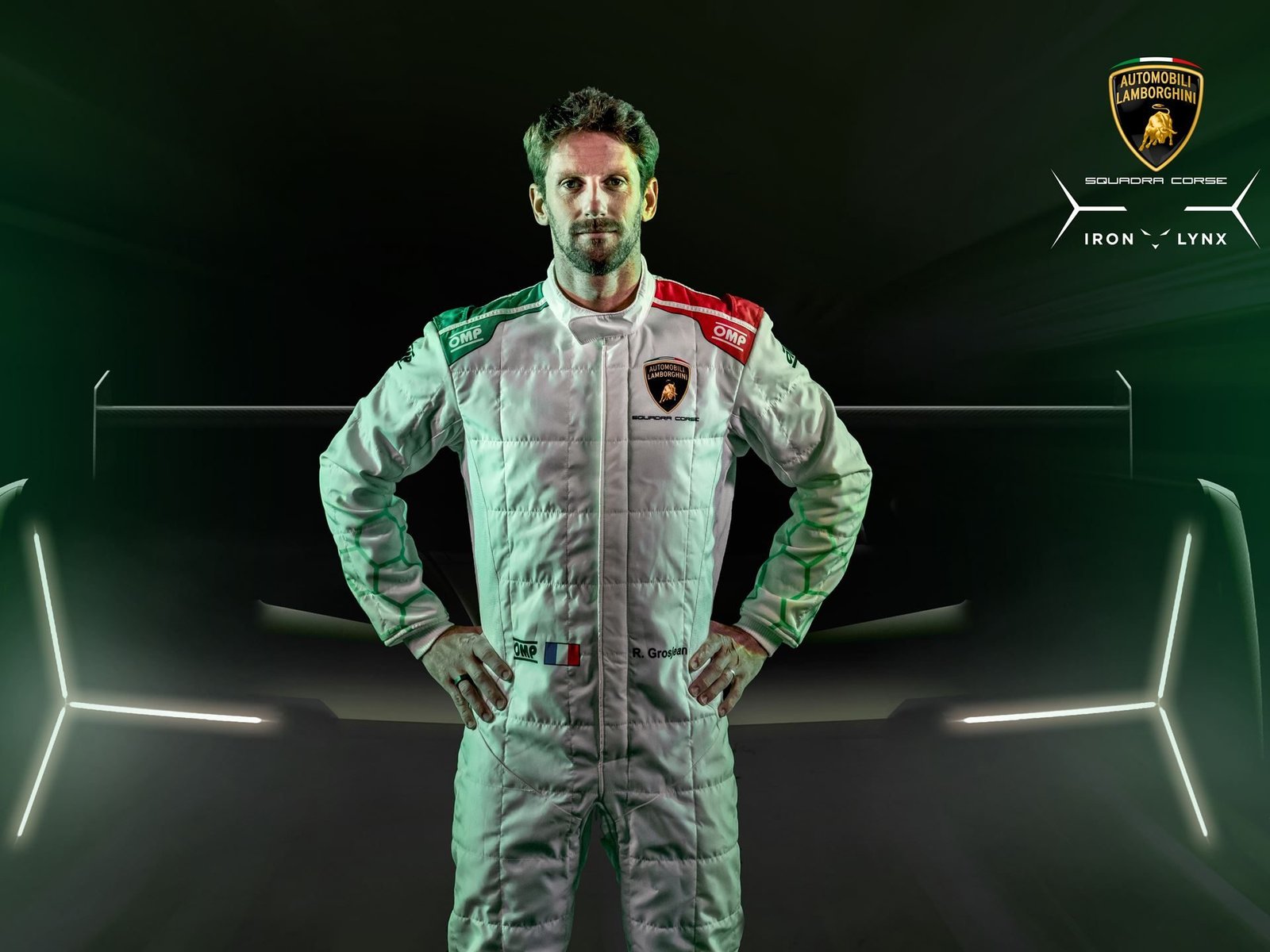 Romain Grosjean in Lamborghini Squadra Corse racing suit standing in front of the SC63 LMDh car