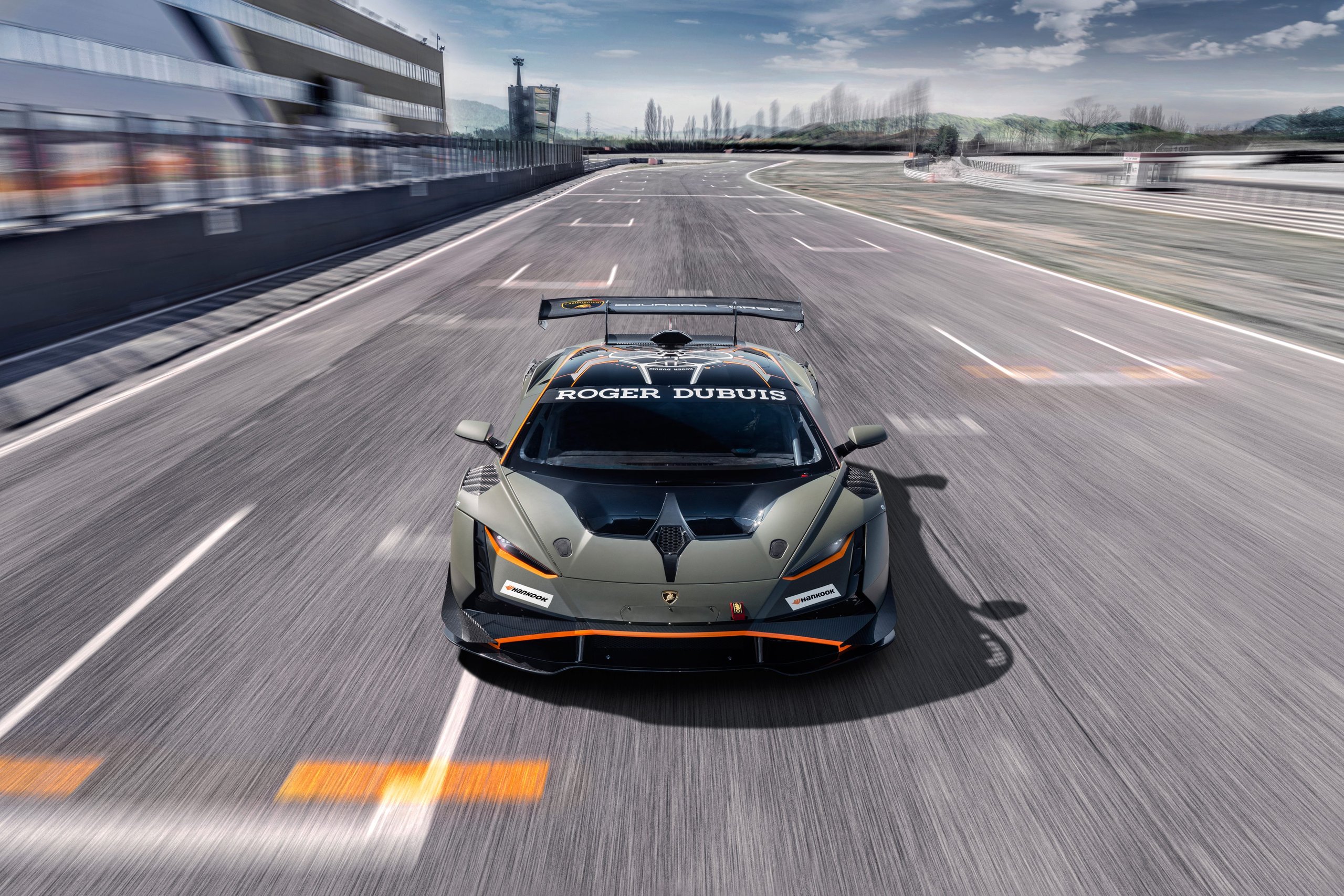 Aerial view of a lamborghini huracán super trofeo evo2 at speed on a straight, showing full aerodynamic package and rear wing