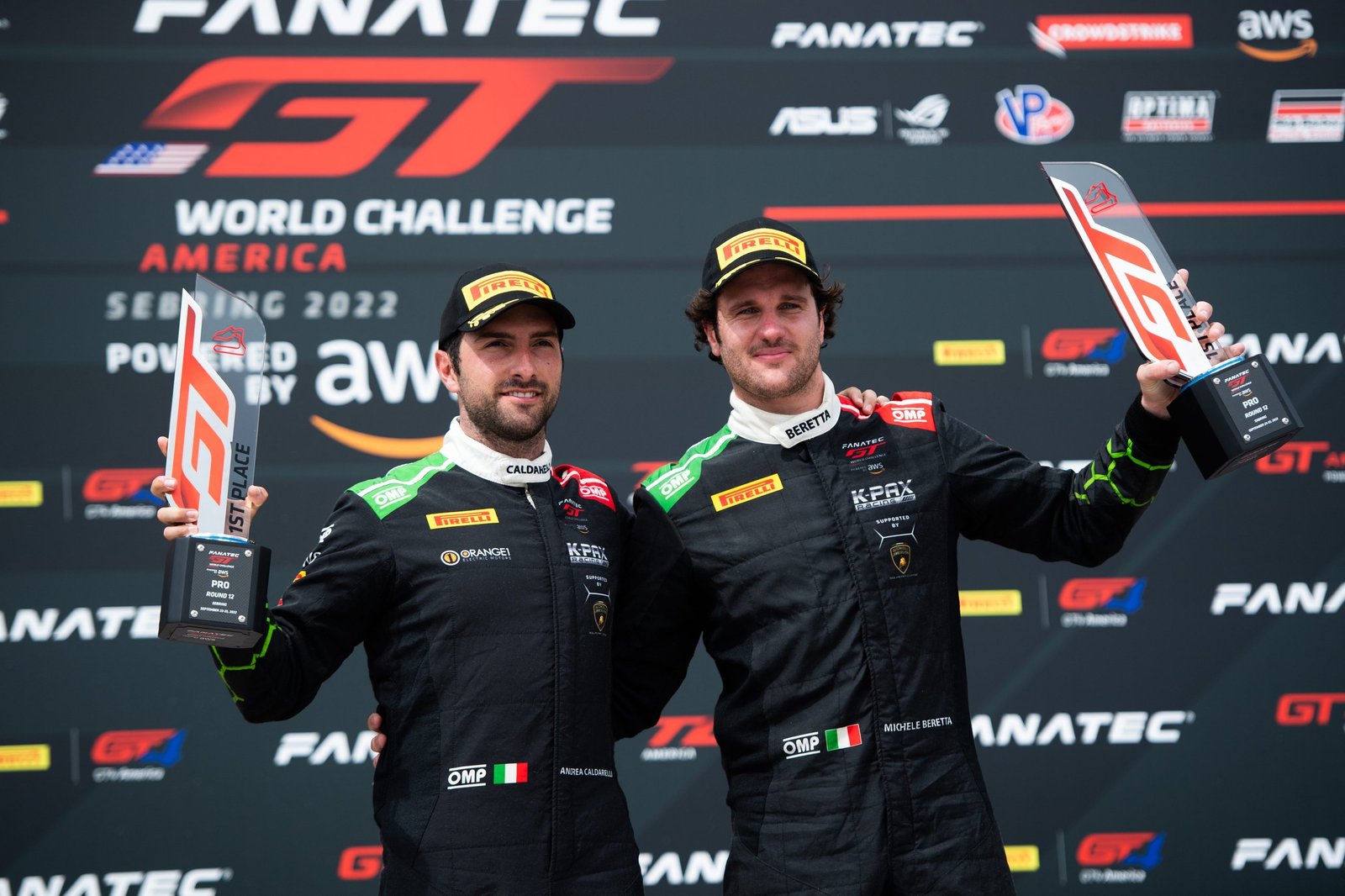 Andrea Caldarelli and Michele Beretta on the podium holding first place trophies at GT World Challenge America Sebring