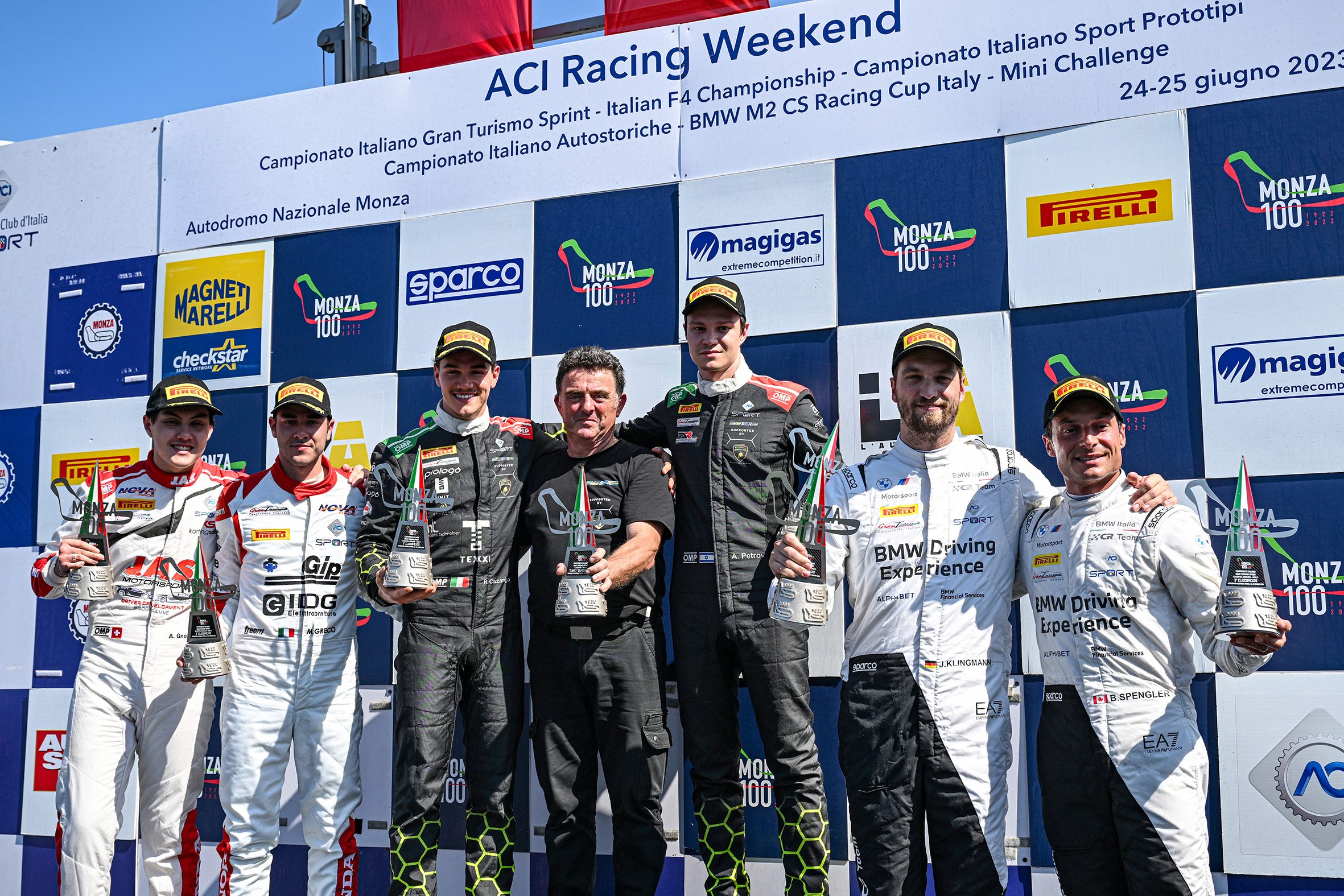 Huracán Gt3 Evo2 Wins On Debut At Monza, Proving Lamborghini'S Customer Racer Arrived Ready 3 Vs racing team members and drivers celebrate on the podium with trophies after the italian gt championship win at monza