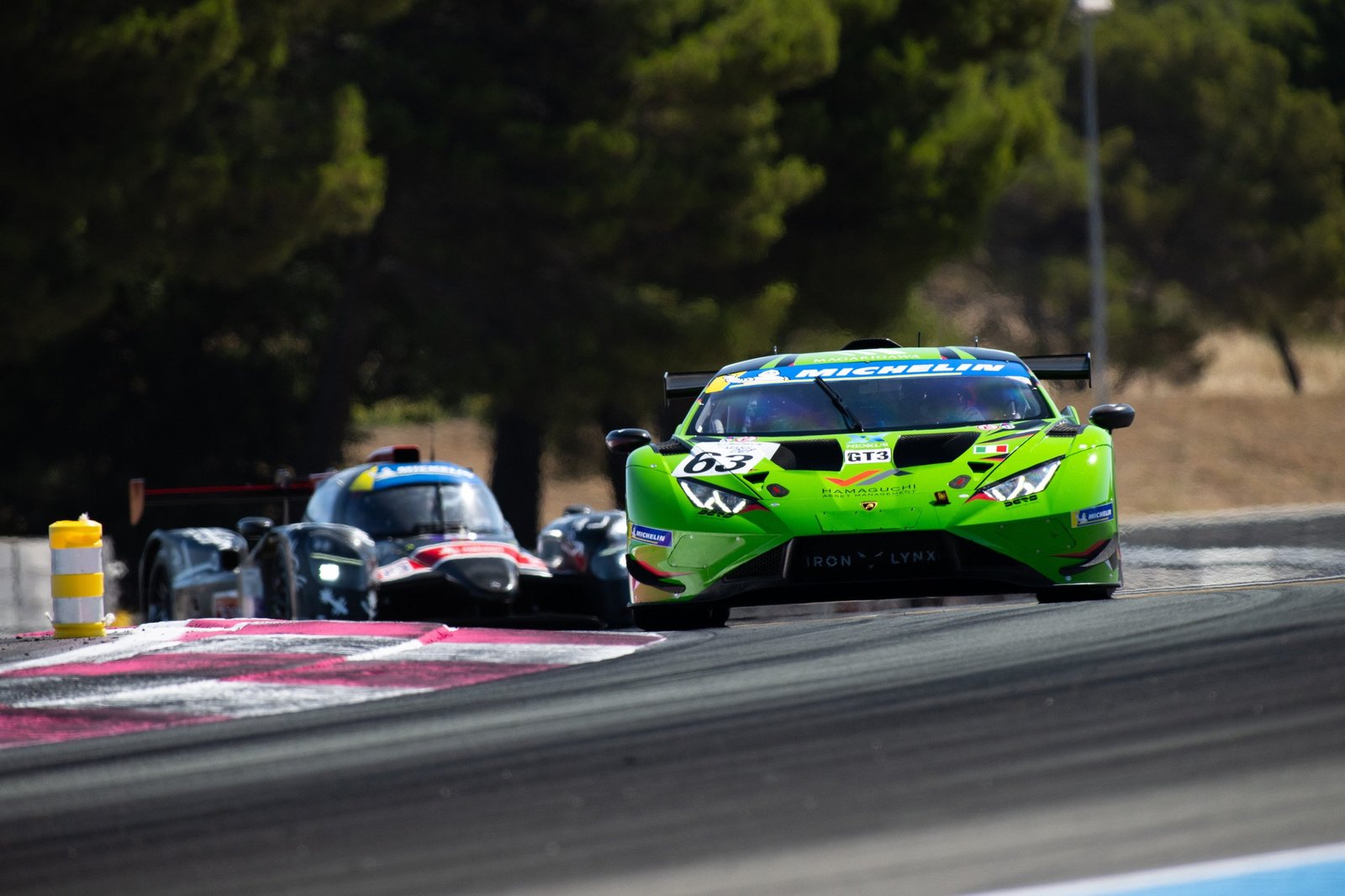 Green Lamborghini Huracán GT3 EVO2 number 63 leading a competitor on track