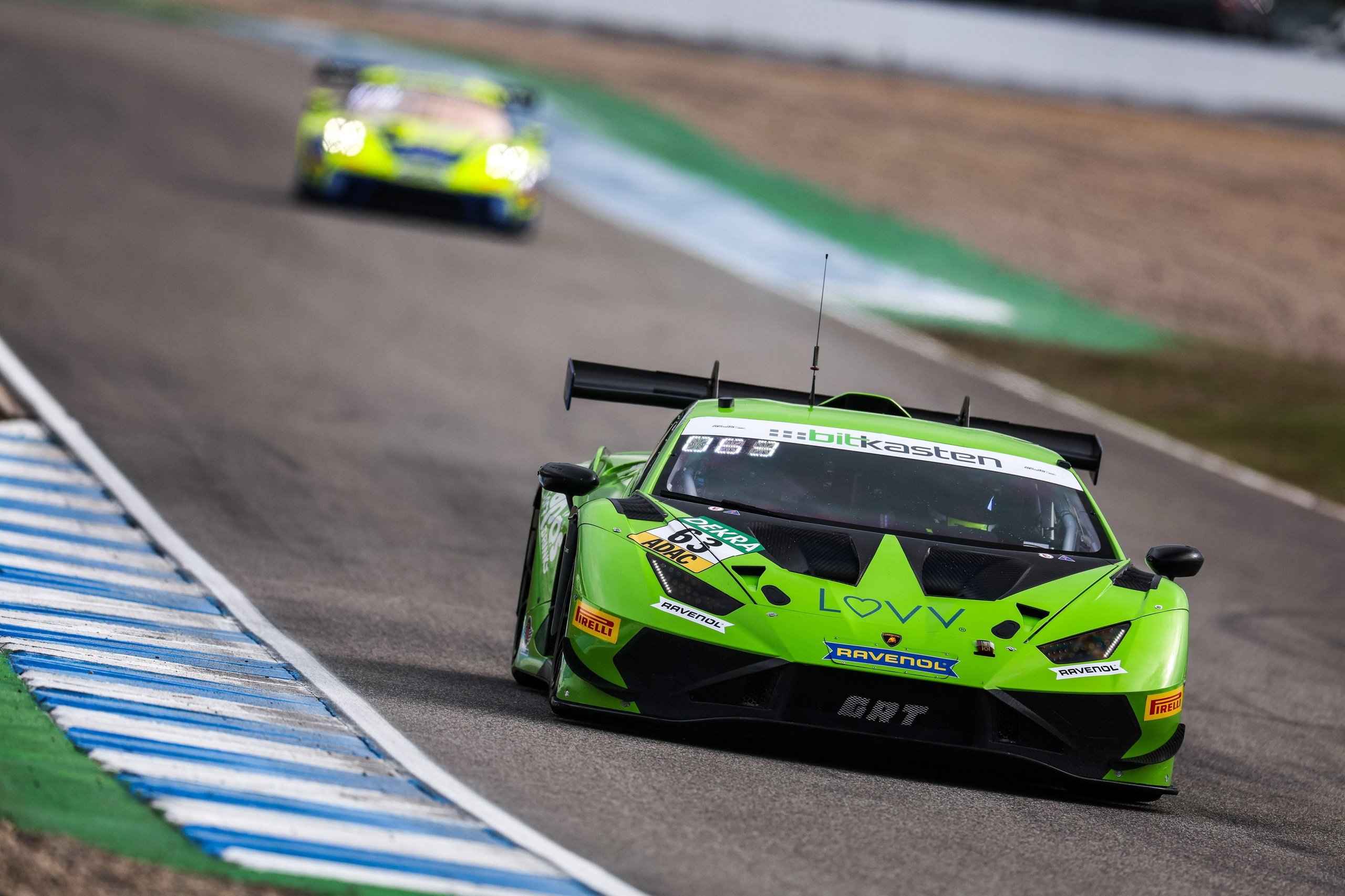 The #63 green lamborghini huracán gt3 evo2 with iron lynx livery leading another car on track, showcasing the car's aggressive aerodynamic package