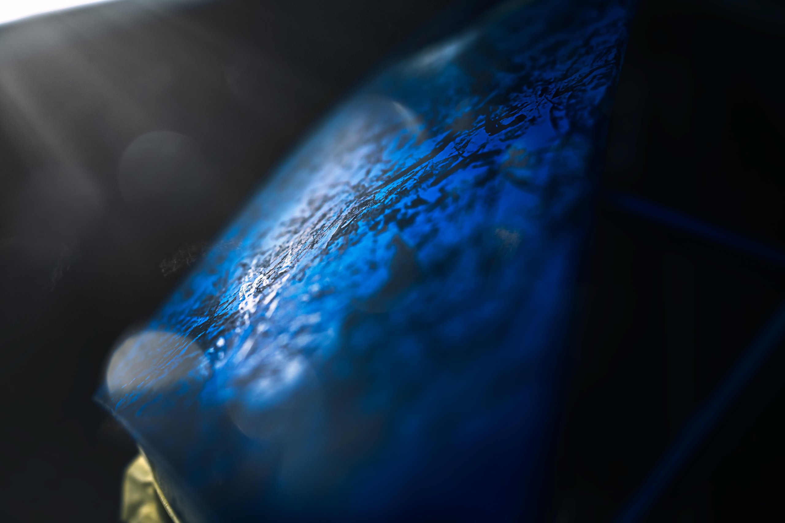 370 Hours Of Paint, One Sardinian Night: Inside The Huracán Sterrato Opera Unica 9 Extreme close-up of the blue and black marbled crystal-effect paint showing intricate texture and light reflections