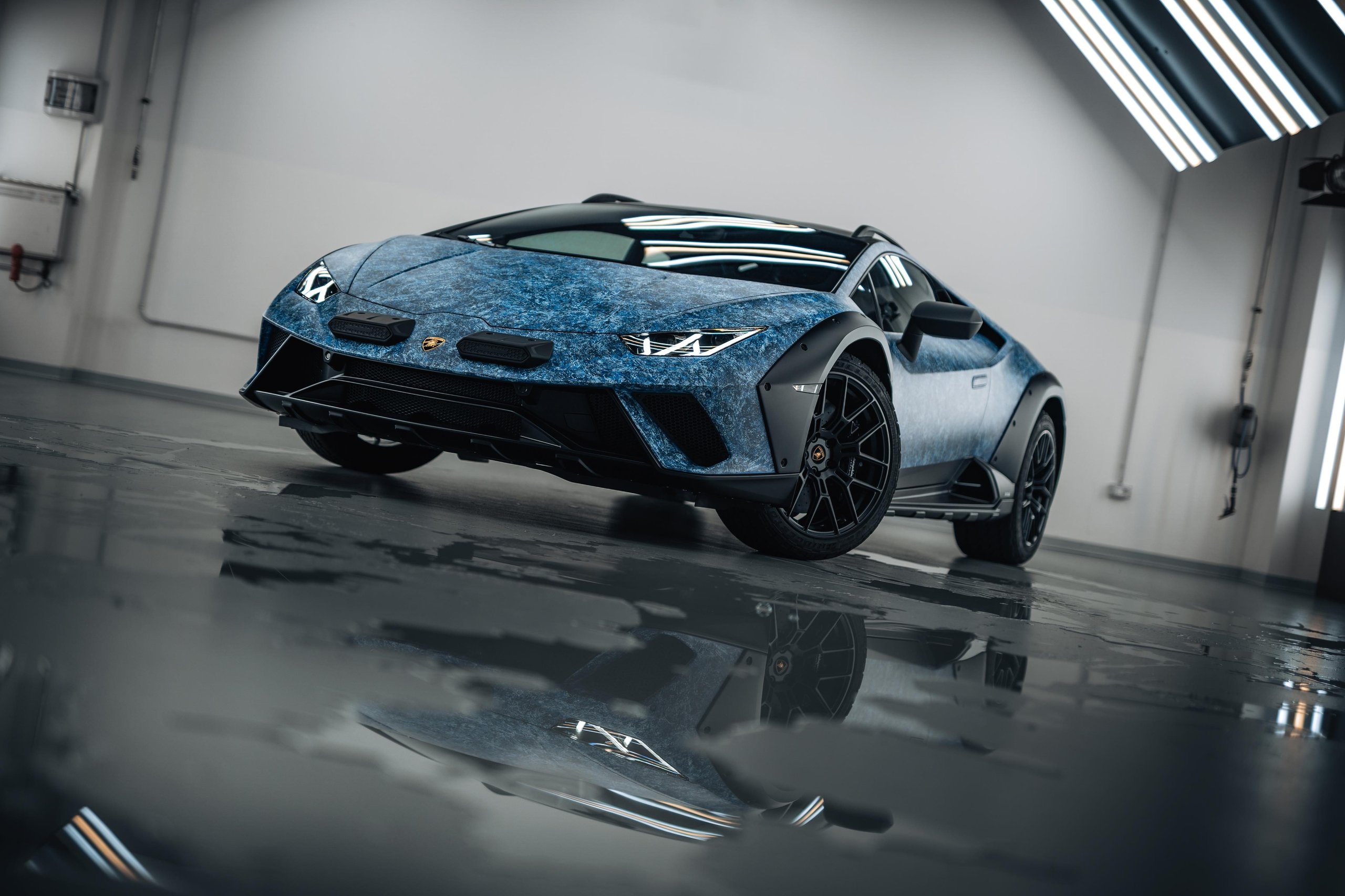 370 Hours Of Paint, One Sardinian Night: Inside The Huracán Sterrato Opera Unica 11 Low-angle wide shot of the huracán sterrato opera unica showing the full blue crystal-effect exterior with black fender flares and elevated stance