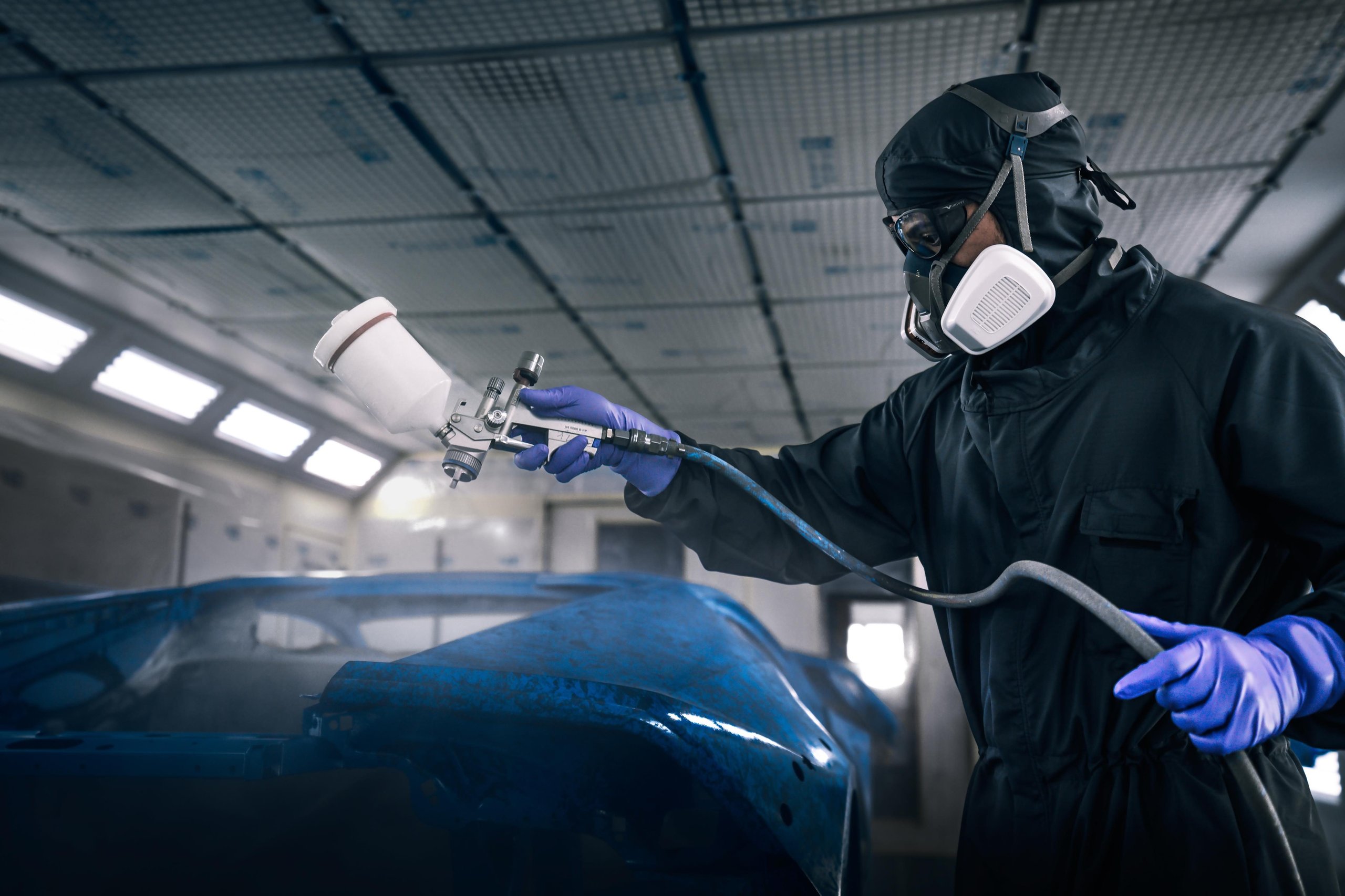 370 Hours Of Paint, One Sardinian Night: Inside The Huracán Sterrato Opera Unica 5 A technician in full protective gear applies the blue crystal-effect paint to the huracán sterrato body panel in a paint booth