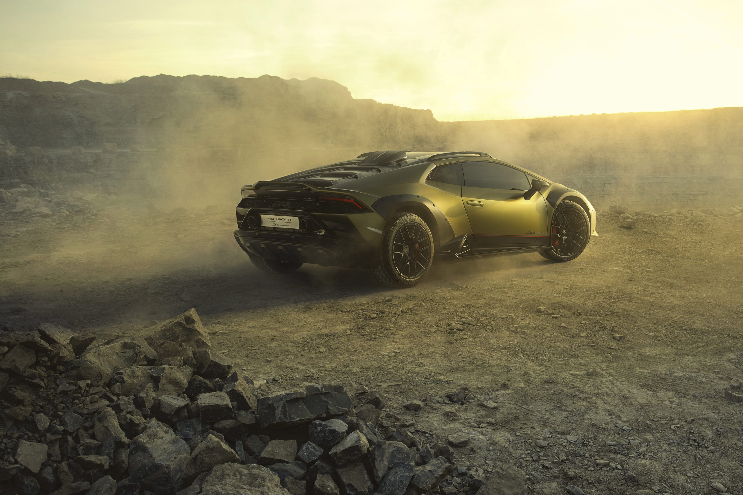 The Huracán Sterrato Sent Lamborghini'S V10 Off The Road And Into Collector History 3 Rear-three-quarter view of lamborghini huracán sterrato in verde gea on dusty terrain at sunset showing rear diffuser, raised ride height, and sterrato badging