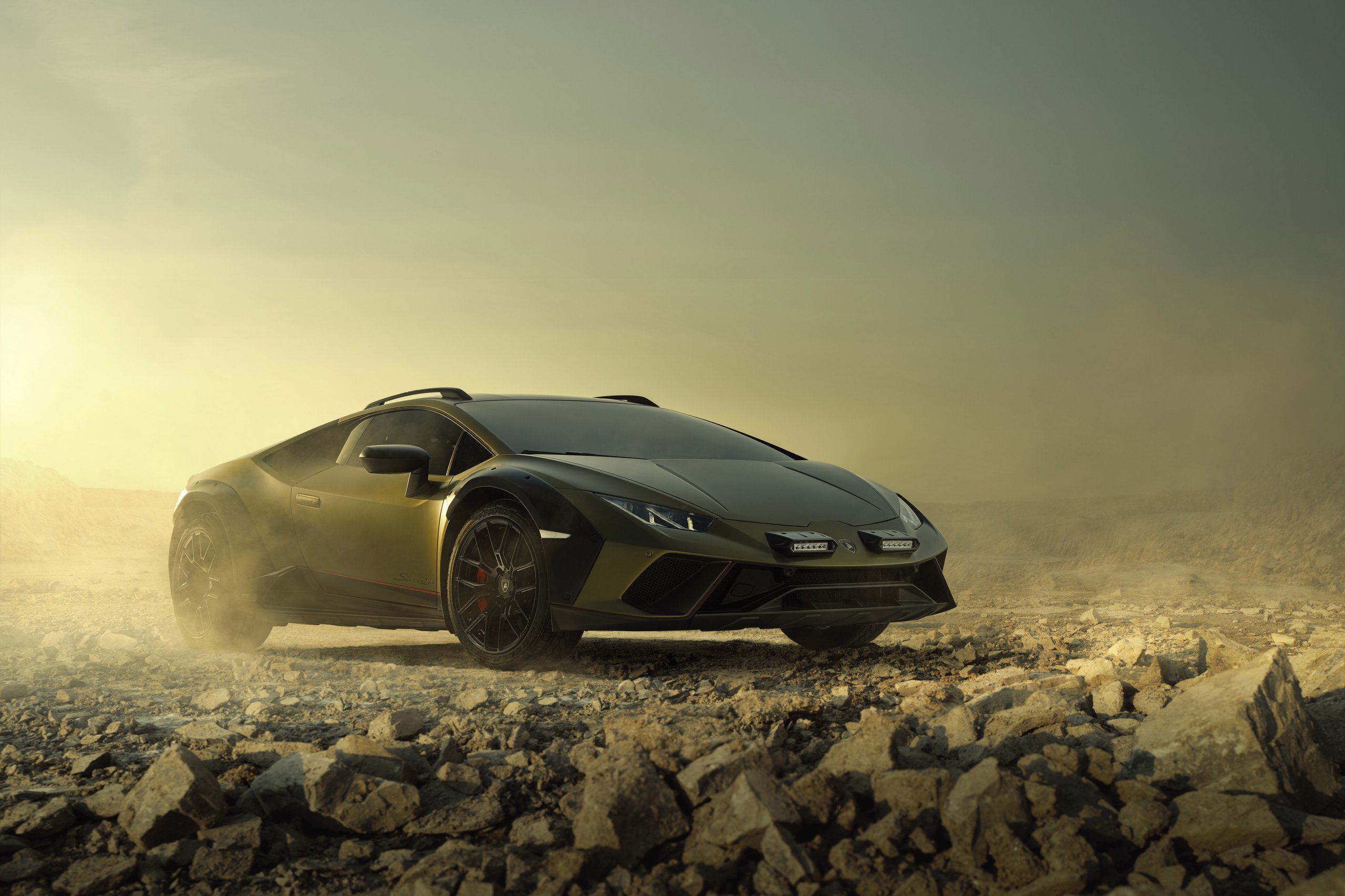 The Huracán Sterrato Sent Lamborghini'S V10 Off The Road And Into Collector History 7 Static shot of lamborghini huracán sterrato in verde gea on rocky terrain showing fender flares, roof rails, front auxiliary lights, and red brake calipers