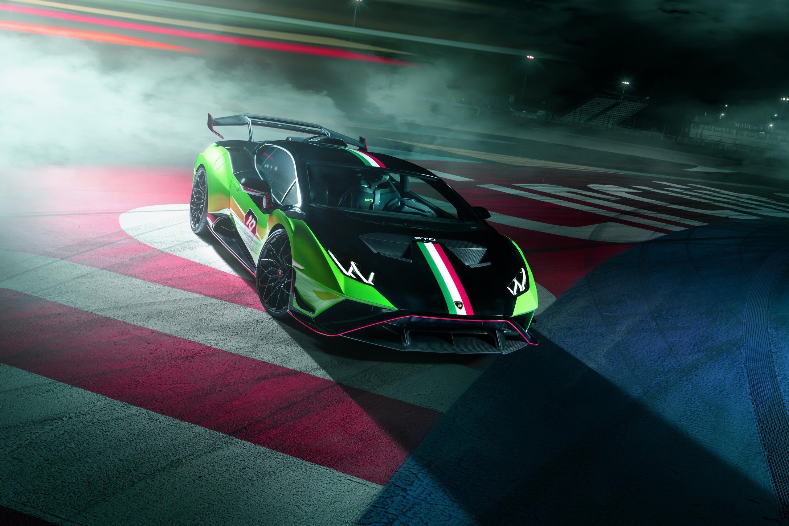 Squadra Corse'S First Road-Car Performance Kit Turns The Huracán Sto Into A Factory-Built Track Weapon 3 Huracán sto sc 10° anniversario parked on track at night showing front splitter, hood vents, italian flag stripe, and rear wing