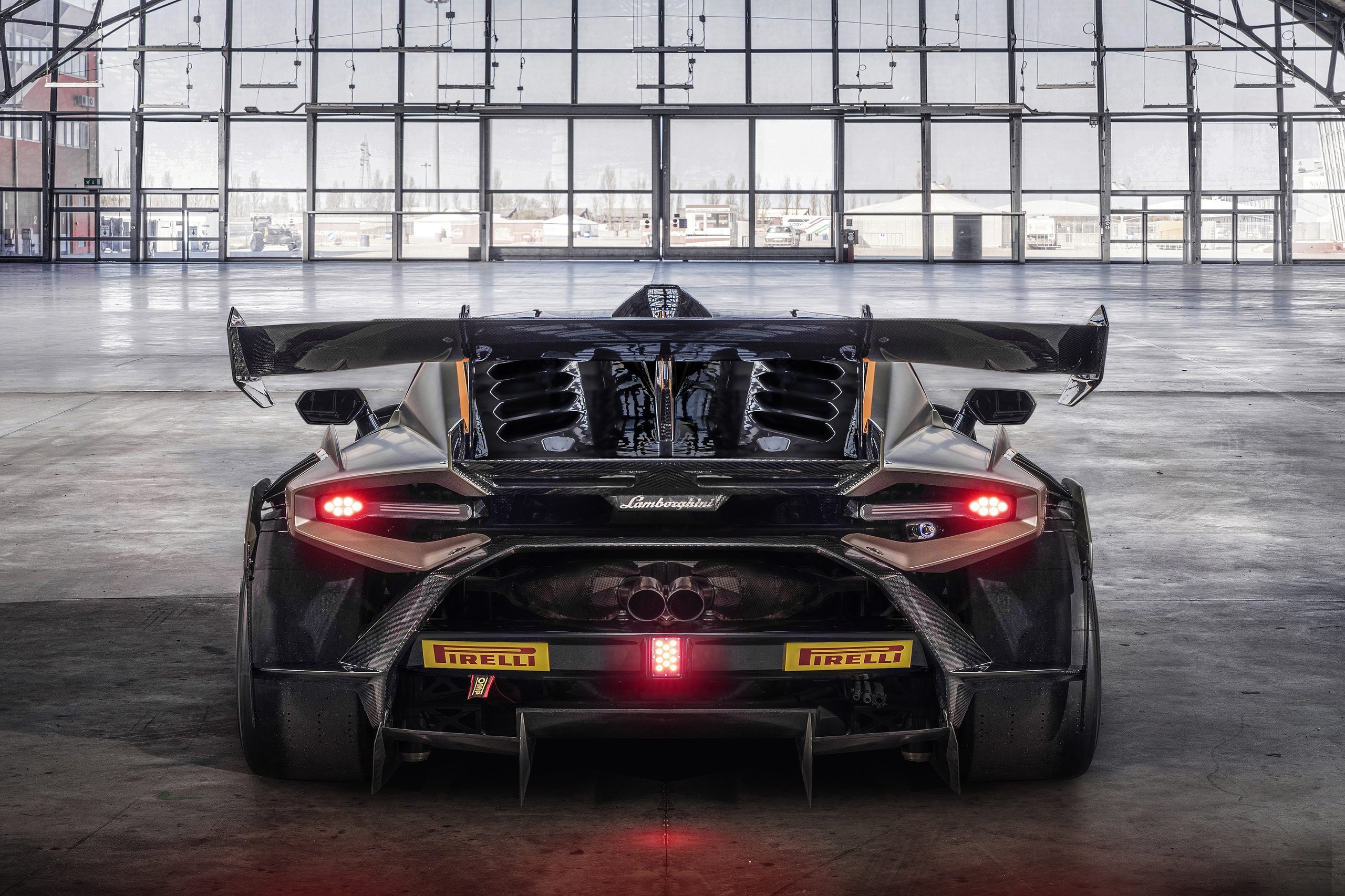 The Huracán Super Trofeo Evo2 Previews Lamborghini'S Next Design Language From The Track 9 Rear view of the huracán super trofeo evo2 in black with orange accents, showing massive diffuser, large rear wing, central exhaust, and countach-inspired led taillights