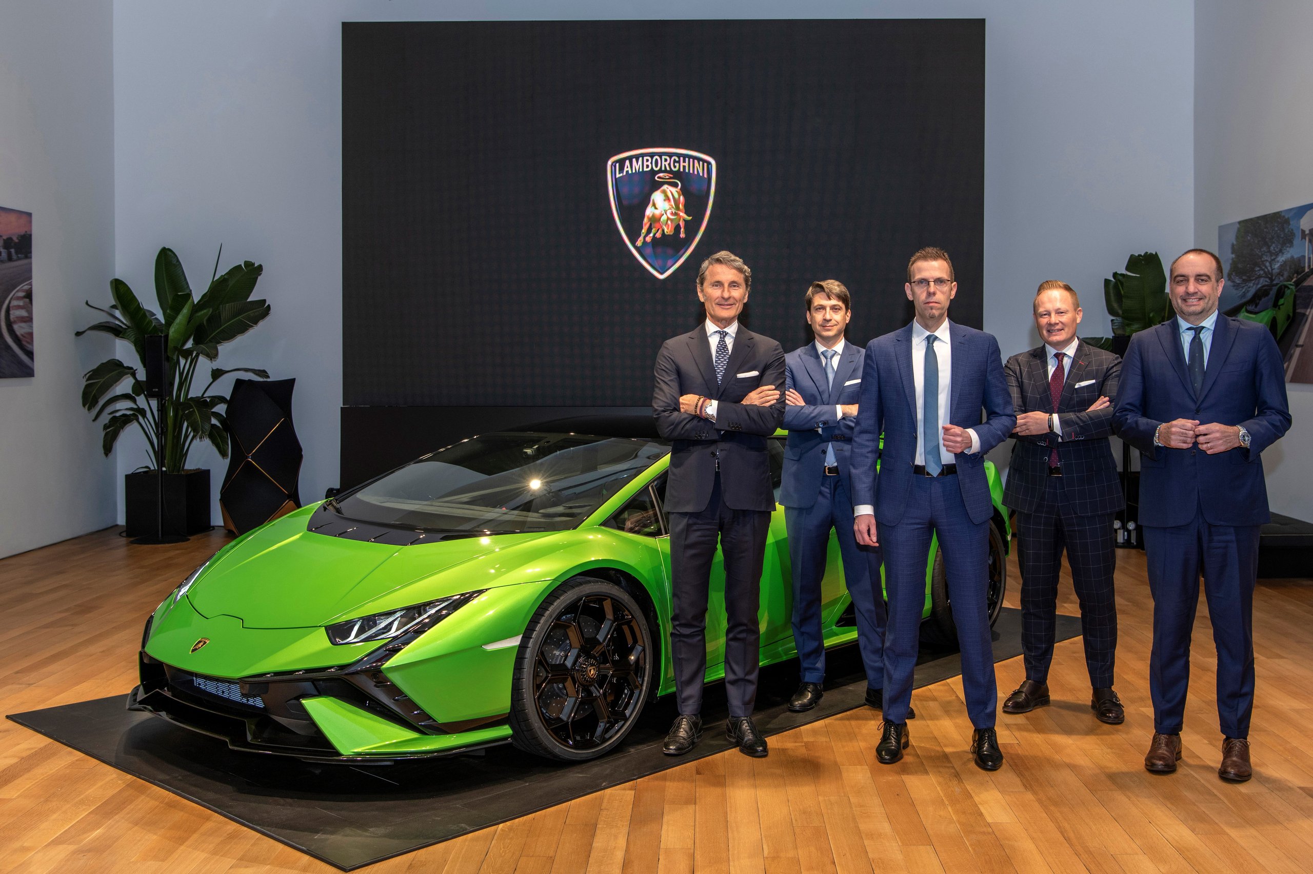 Huracán Tecnica In New York: Why Lamborghini'S V10 Sweet Spot Matters More Than Its Spec Sheet 3 Five lamborghini executives in suits standing beside the green huracán tecnica at the lamborghini lounge nyc premiere event