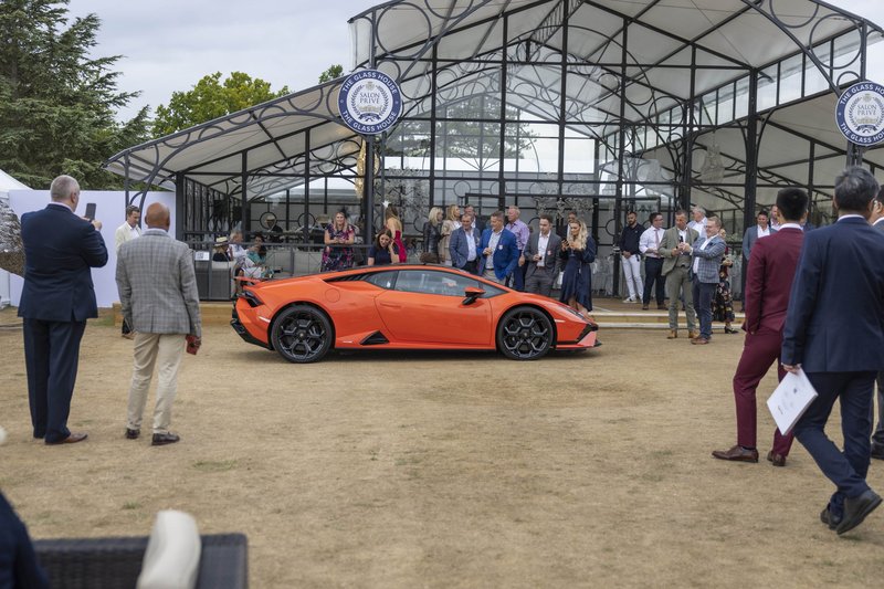 Orange Lamborghini Huracán Tecnica being paraded past elegantly dressed spectators at Blenheim Palace during Salon Privé