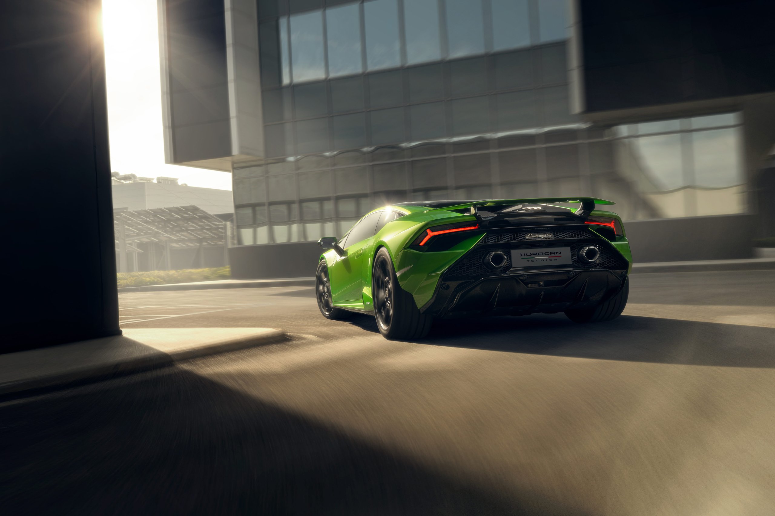Huracán Tecnica: Lamborghini'S Case That The Best V10 Splits The Difference 11 Dynamic rear three-quarter shot of the green huracán tecnica driving away from a building with motion blur indicating speed
