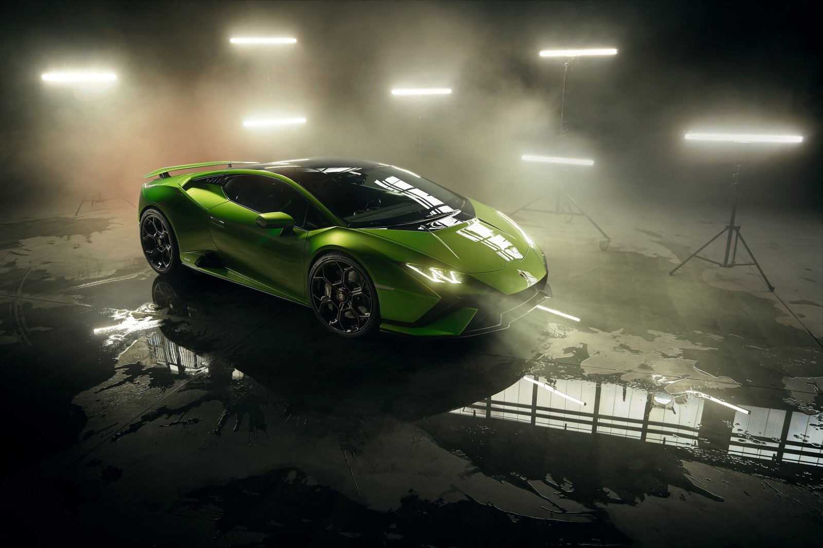 Lamborghini Huracán Tecnica in Verde Mantis green shown in a dramatic smoky studio, displaying its aggressive front fascia, fixed rear wing, and hexagonal wheel design