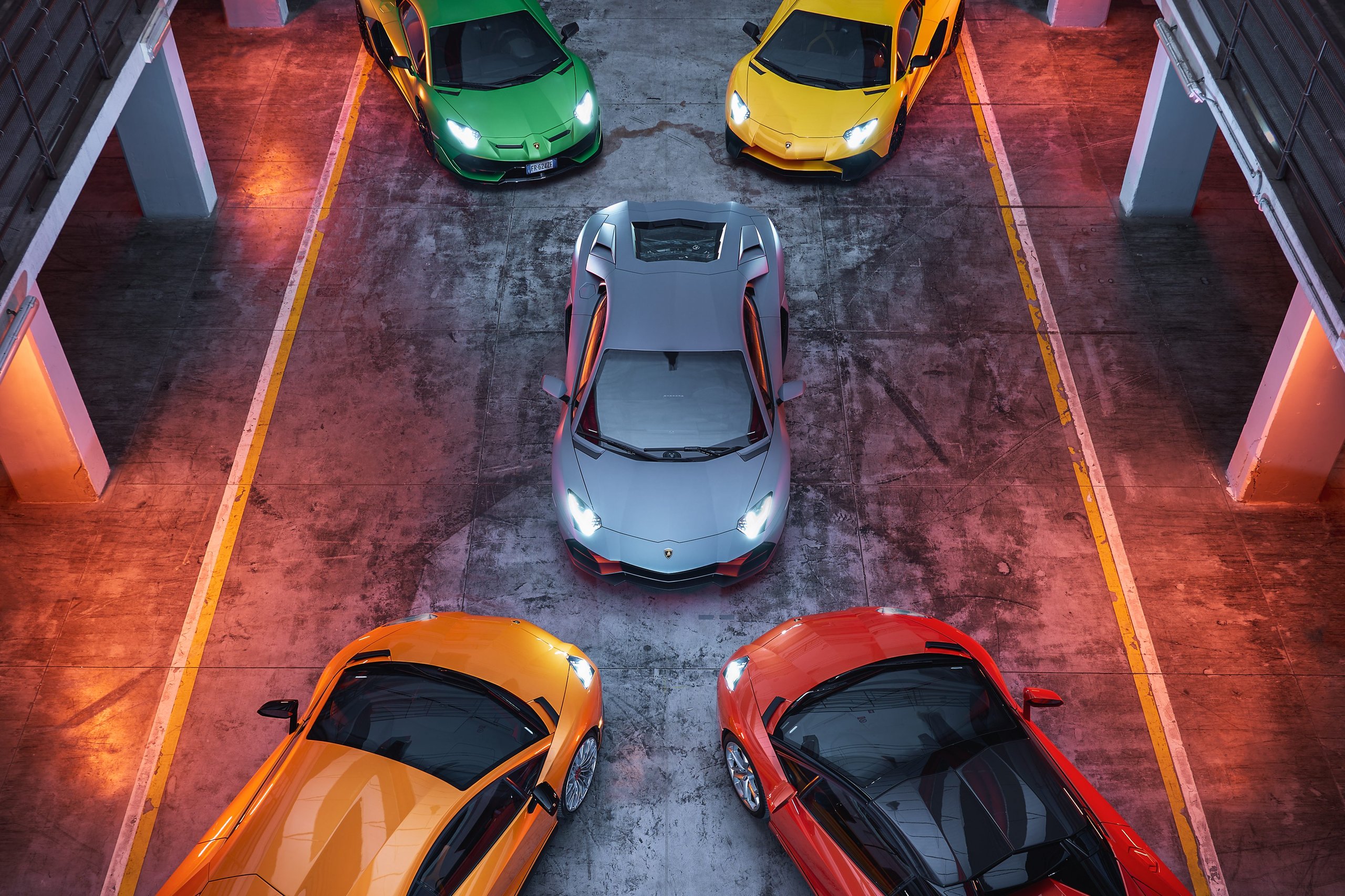 How Lamborghini'S Record 2022 Financials Bankrolled A Hybrid Revolution That Rivals Still Chase 9 Top-down view of five colorful lamborghini supercars including huracán and aventador models in a stylized studio setting