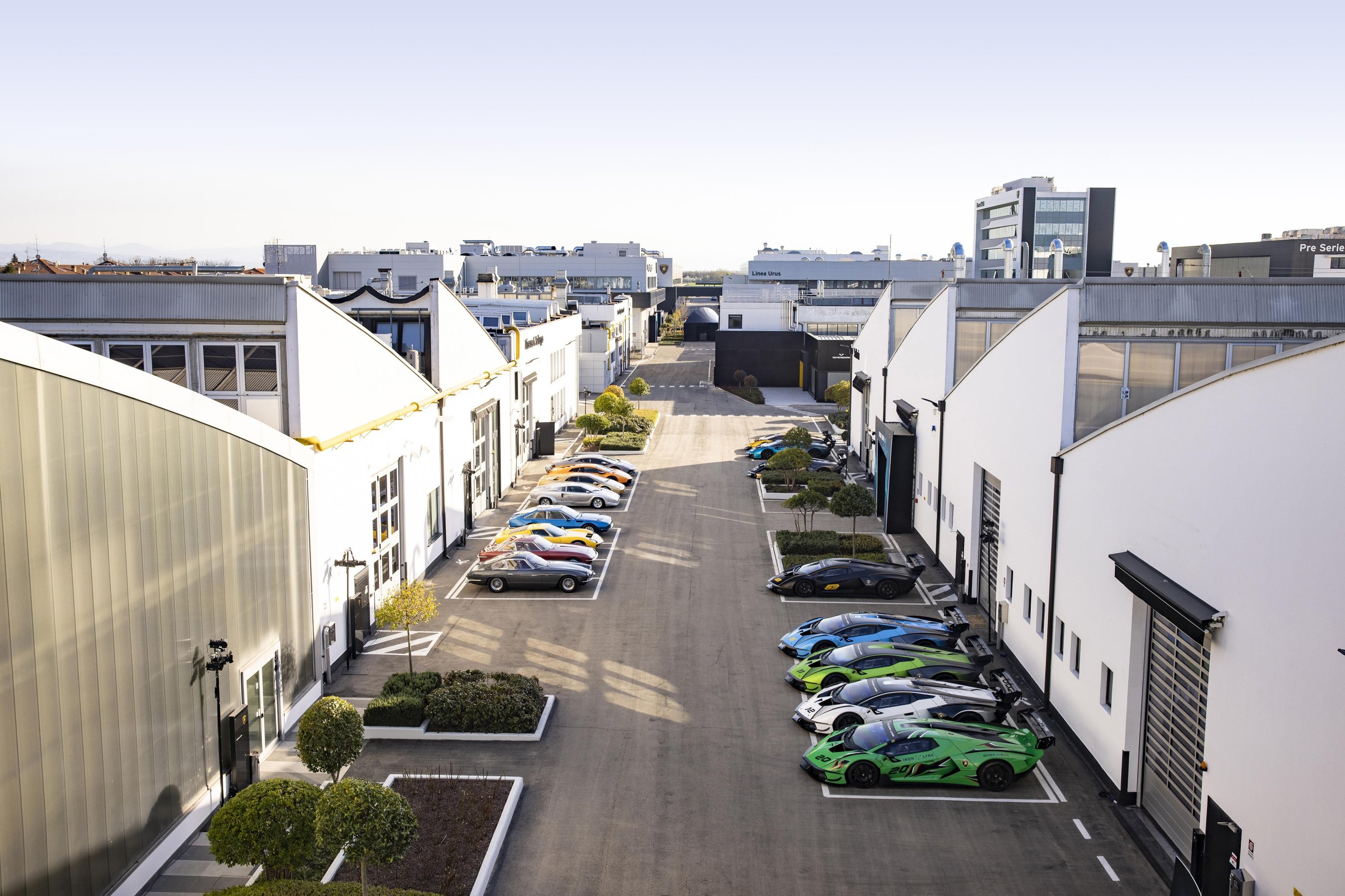 Aerial view of lamborghini factory grounds showing classic and modern lamborghini cars parked between buildings