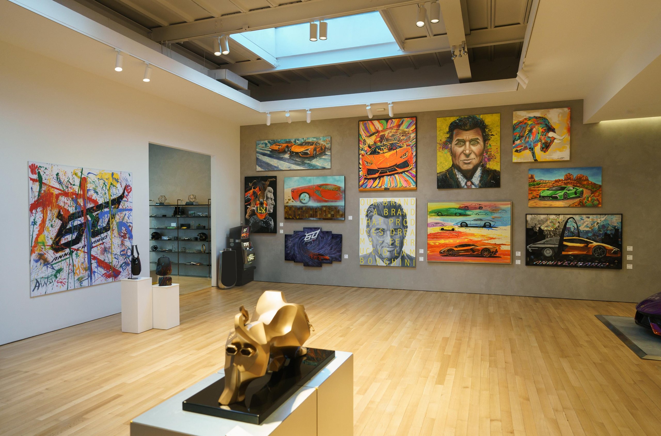 Why Lamborghini Opened Its Private Nyc Lounge To The Public For The First Time 11 Wide gallery view with golden bull sculpture and wall of lamborghini-themed artworks at the 60th anniversary exhibition