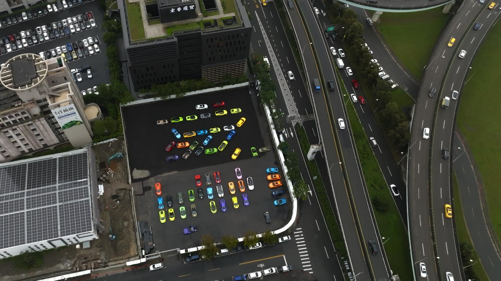 Seventy Lamborghinis, One Kinetic Sculpture, And Taiwan'S Eastern Coast: Inside The 60Th Anniversary Esperienza Giro 3 Aerial view of dozens of colorful lamborghini vehicles gathered in an urban staging area before the esperienza giro taiwan flag-off
