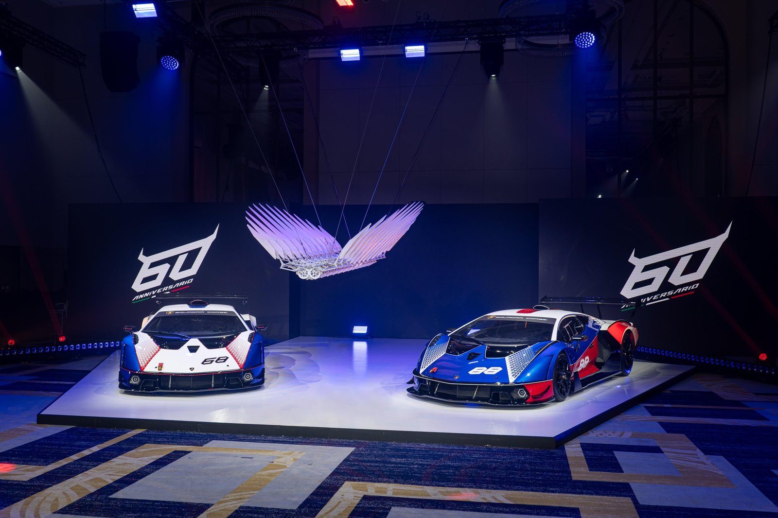 Two Lamborghini Essenza SCV12 hypercars displayed on stage beneath the LL60 kinetic sculpture at the 60th anniversary gala in Taipei