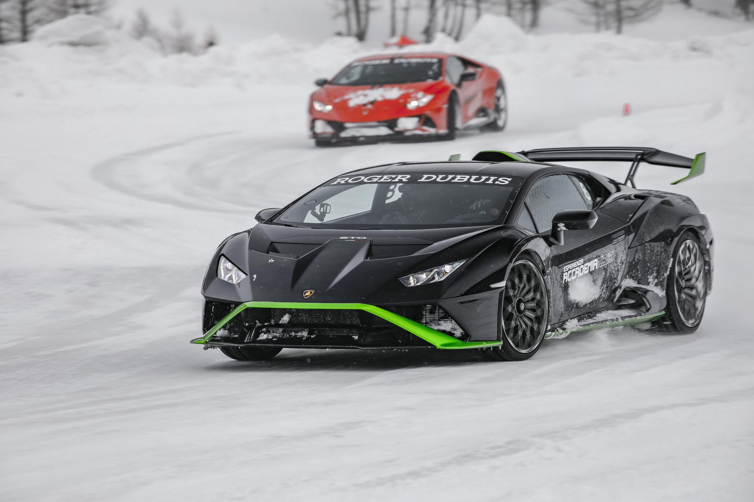 Accademia Neve 2022: What Lamborghini'S Ice Driving Program Actually Teaches Owners About Their Cars 7 Black lamborghini huracán sto with green accents driving on snowy track with red huracán visible in background at accademia neve 2022