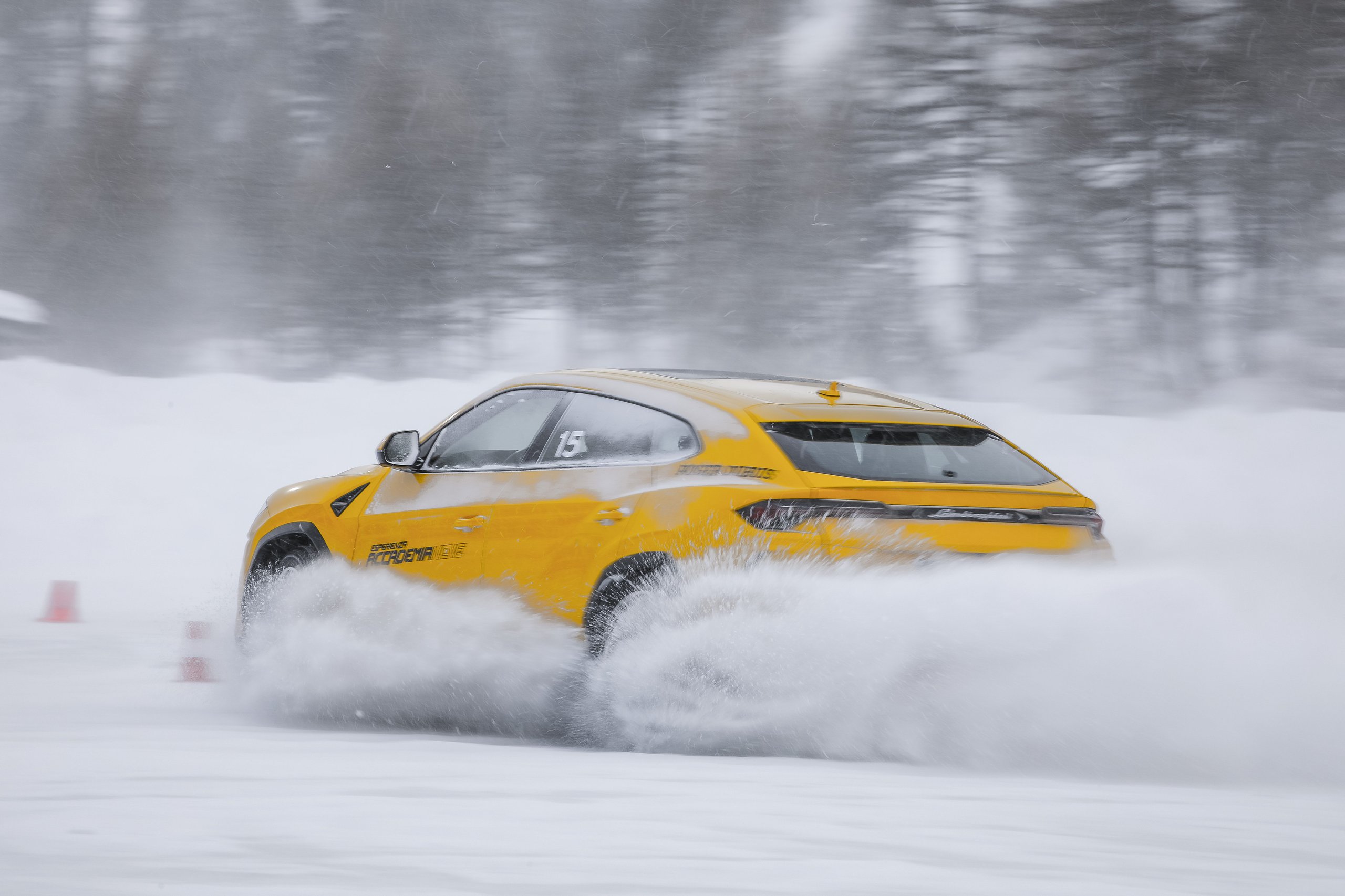 Accademia Neve 2022: What Lamborghini'S Ice Driving Program Actually Teaches Owners About Their Cars 9 Yellow lamborghini urus kicking up a large cloud of snow while driving on a snowy track at accademia neve 2022