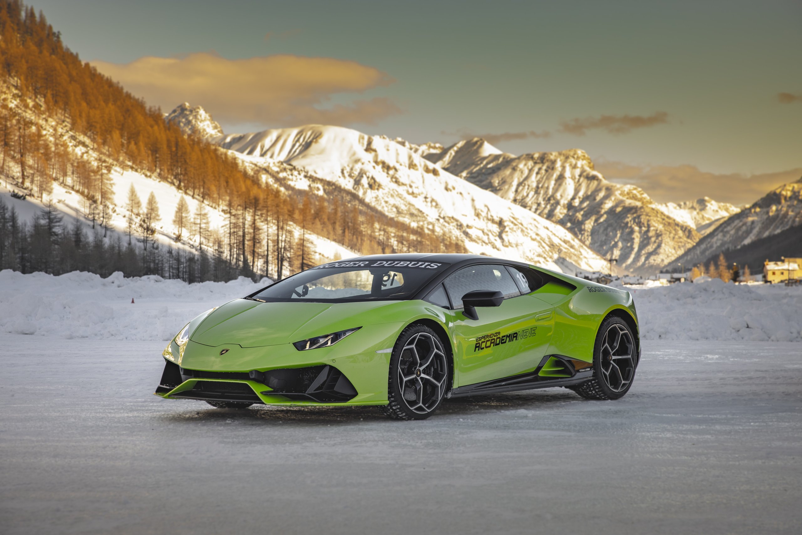 Accademia Neve 2022: What Lamborghini'S Ice Driving Program Actually Teaches Owners About Their Cars 5 Vibrant green lamborghini huracán evo parked on a pristine snowfield with snow-covered mountains and golden sky at accademia neve 2022