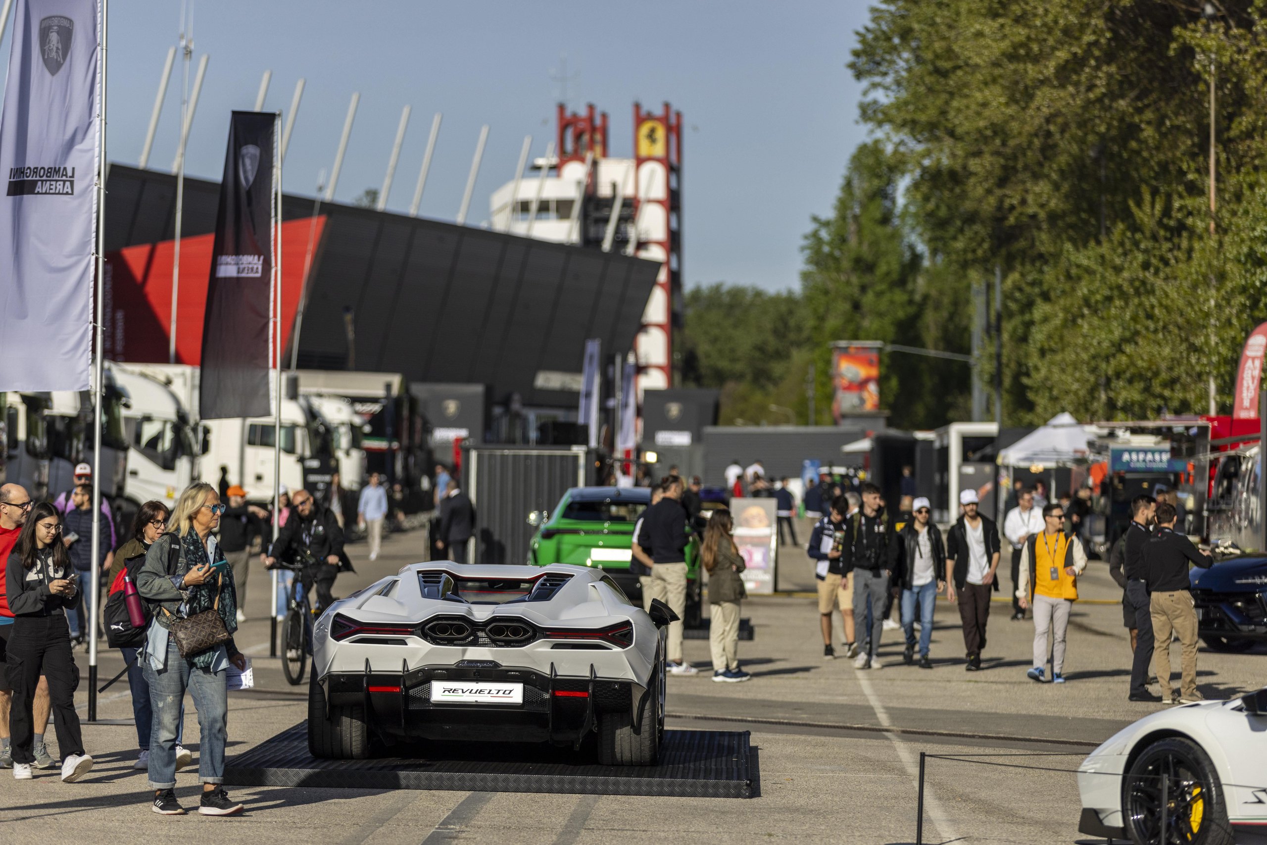 Lamborghini Arena 2026 Returns To Imola: Why The Brand'S Biggest Owner Gathering Matters More This Time 7 A white lamborghini revuelto displayed on a platform at the arena event with a green urus and crowd in the background