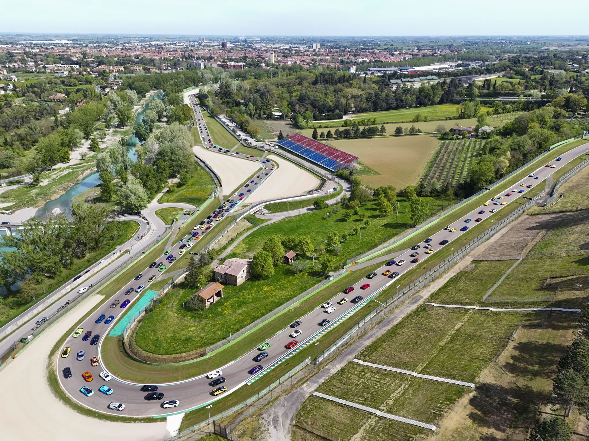 Lamborghini Arena 2026 Returns To Imola With Super Trofeo Racing, Miura Anniversary, And A Bigger Playbook 3 Aerial view of hundreds of lamborghini models filling the imola circuit during a parade lap at lamborghini arena