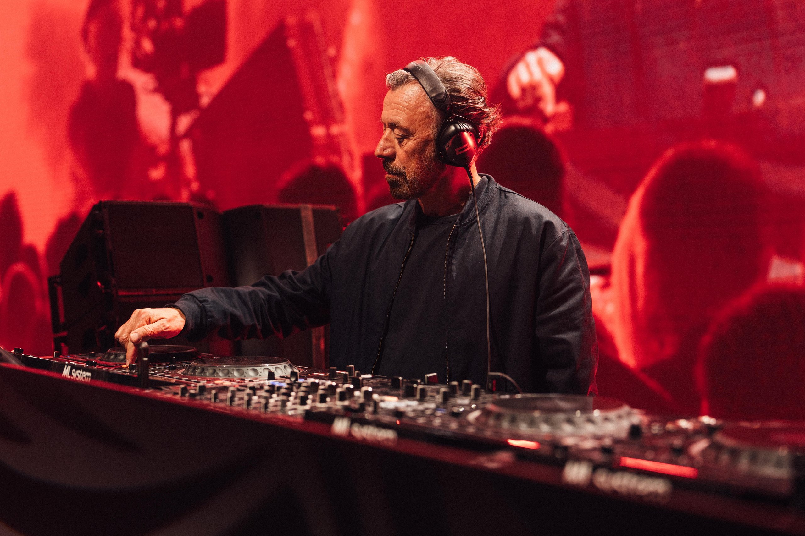 Why Lamborghini Hired Benny Benassi To Turn Arena Into A Homecoming For 6,000 Owners 11 Dj benny benassi wearing headphones and focused on his equipment during a performance with red-lit background