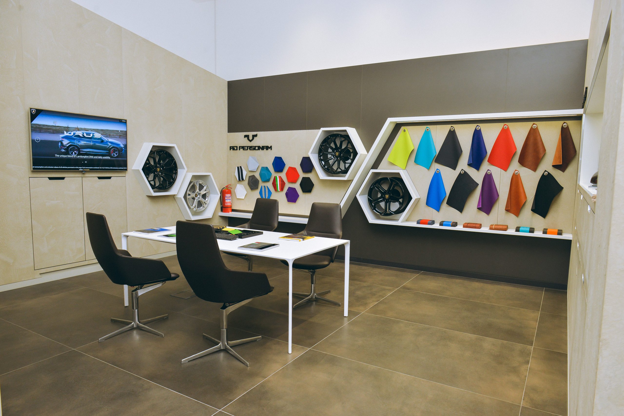 Lamborghini Baku: Why A 225 Square Meter Showroom Signals Serious Ambitions For The Transcaucasia Region 5 Interior of the lamborghini ad personam studio in baku showing a consultation table, large screen displaying a urus, and walls with color and material samples