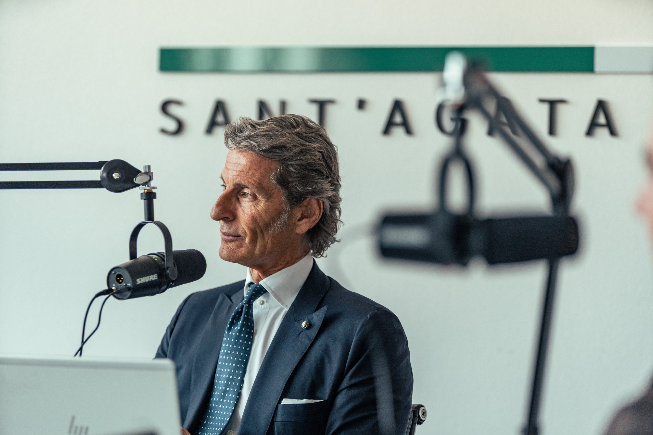 Stephan winkelmann seated in a recording studio with a shure microphone during the beyond podcast recording