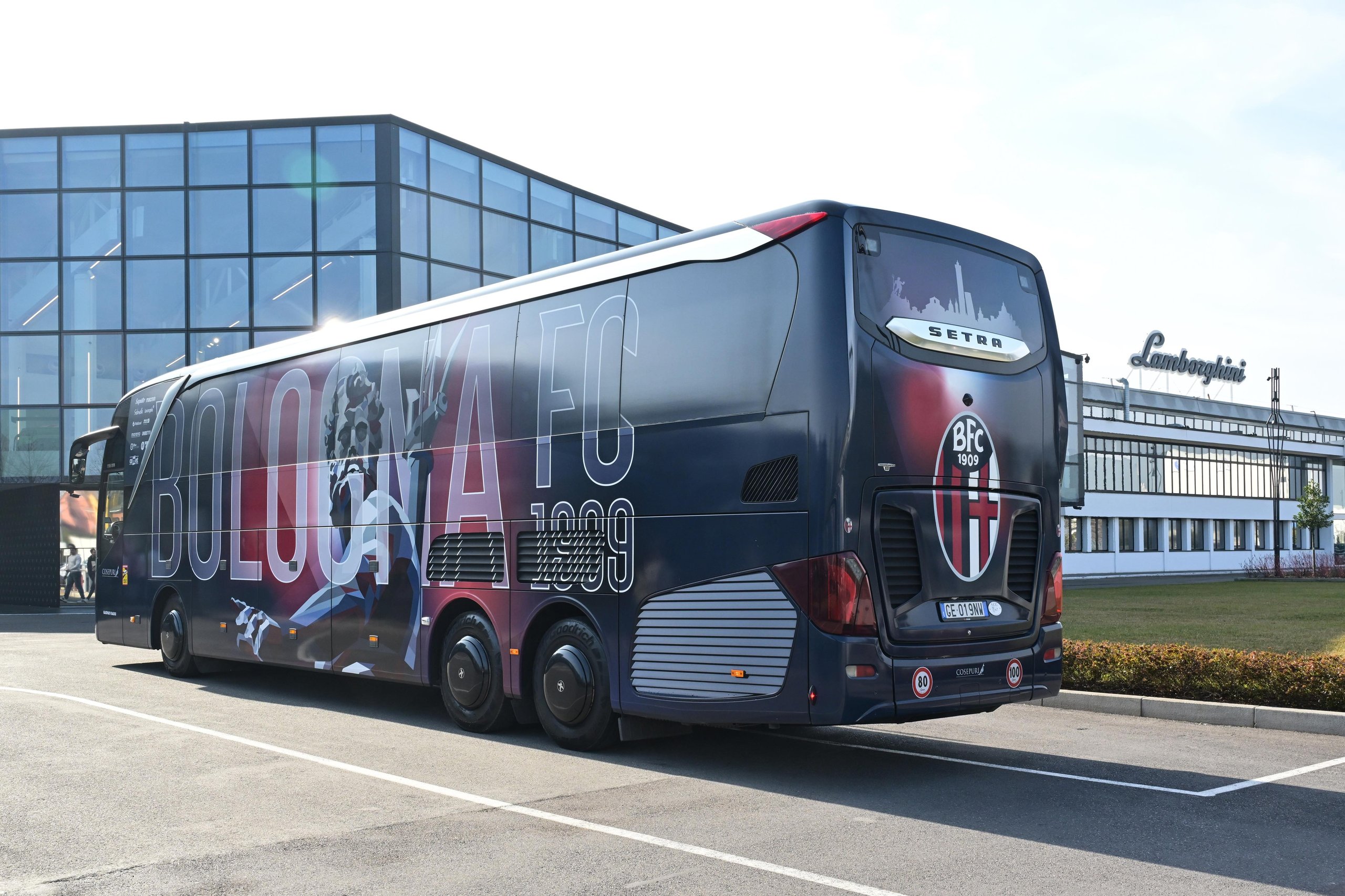 Lamborghini Brings Bologna'S Women'S Football Team To Sant'Agata, Signaling A Broader Brand Play 9 A dark blue bologna fc team bus branded with lamborghini and bologna fc logos parked outside a modern building