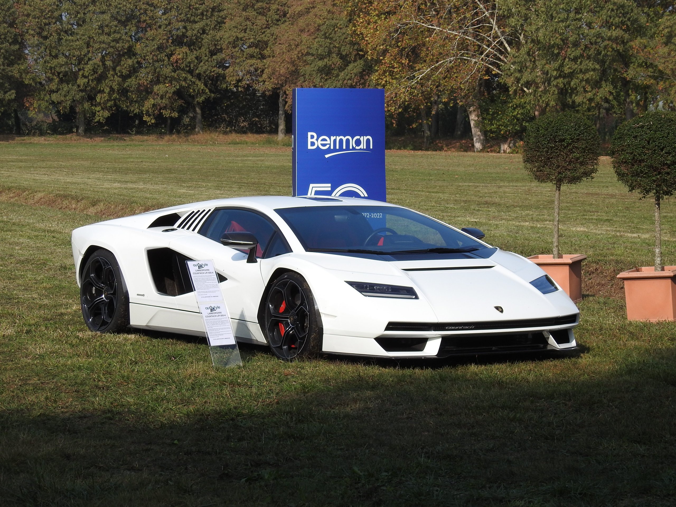 Mitja Borkert Used The Autostyle Stage To Explain Why Every Lamborghini Starts With A Single Line 5 White lamborghini countach lpi 800-4 on green grass with berman sign and trees in background at the autostyle event