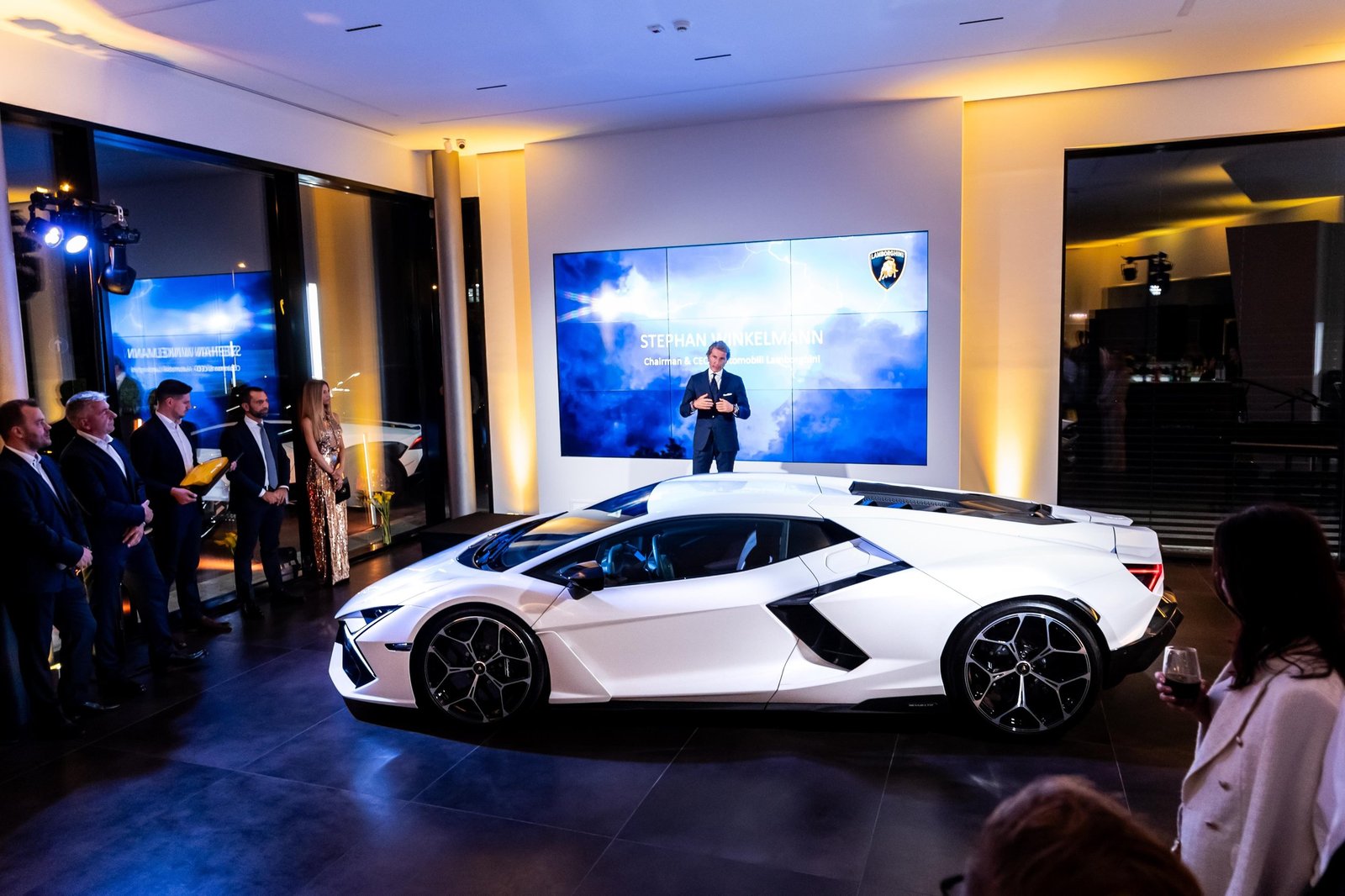 Stephan Winkelmann presents the white Lamborghini Revuelto on stage at the Budapest showroom grand opening