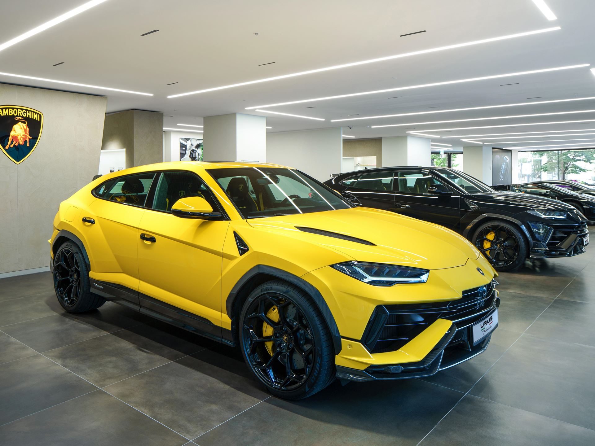 Lamborghini Bundang Puts The Urus Se On Stage For South Korea'S Tech Corridor 5 A bright yellow lamborghini urus displayed in the bundang showroom with a black urus visible behind it