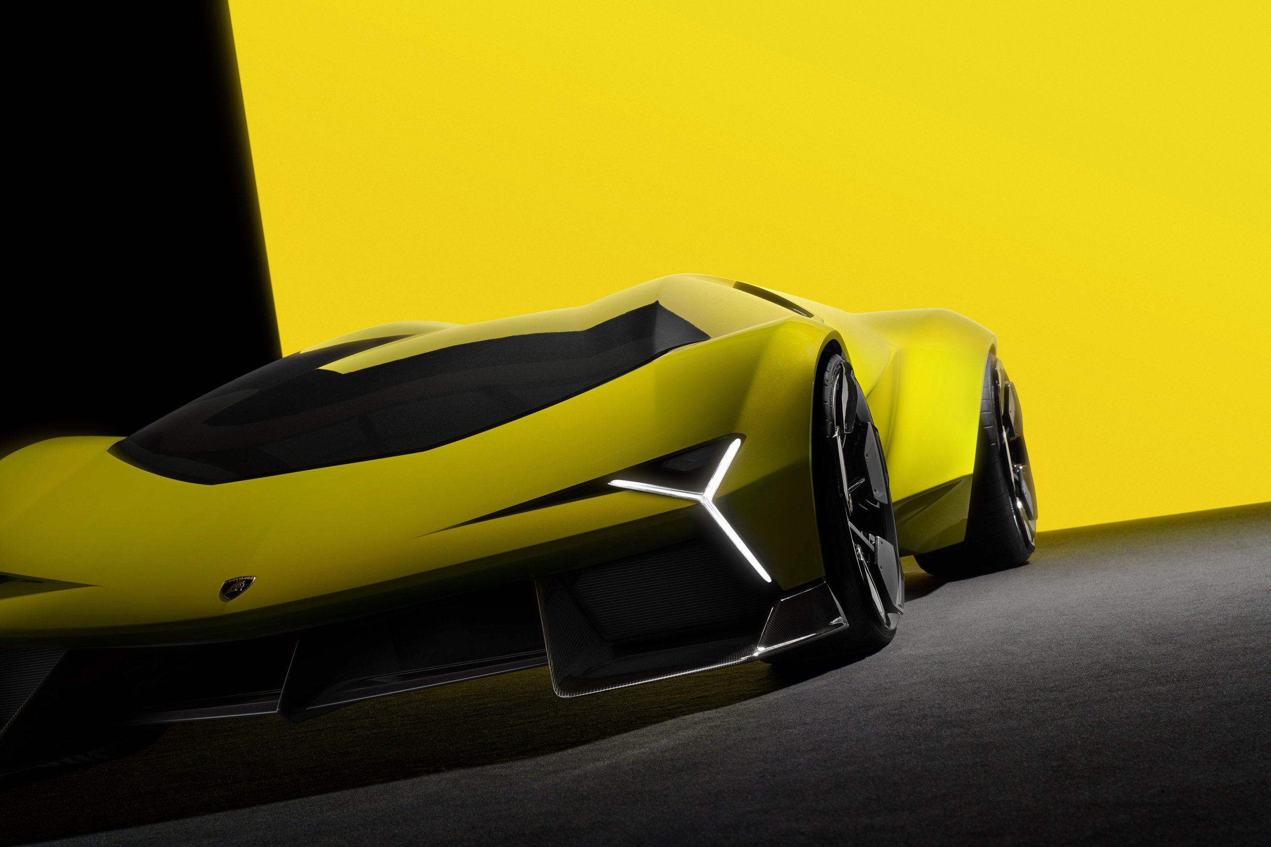 Low-angle front three-quarter view of the yellow Lamborghini V12 Vision Gran Turismo concept showing Y-shaped headlights and aggressive aerodynamic lines