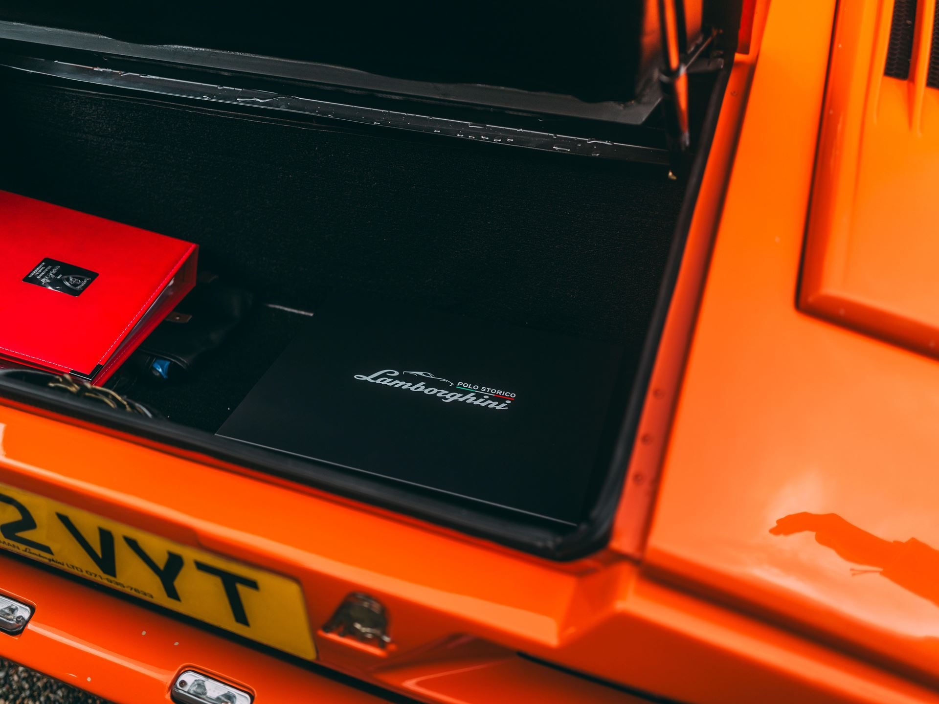 Two Trophies, Four V12S: Lamborghini'S Strongest Villa D'Este Showing In Years 3 Polo storico lamborghini branded cover visible in the rear trunk of the orange countach 25th anniversary at villa d'este