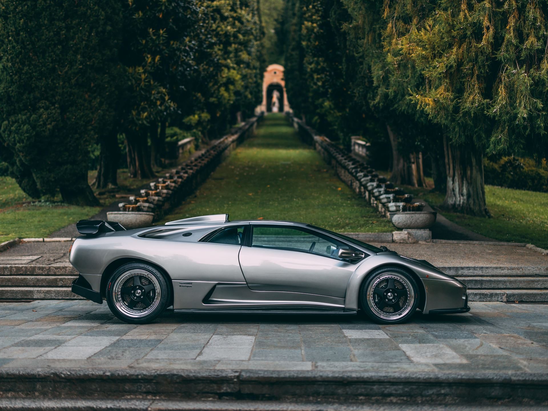 Two Trophies, Four V12S: Lamborghini'S Strongest Villa D'Este Showing In Years 7 Silver lamborghini diablo gt parked on stone steps at a grand estate surrounded by trees