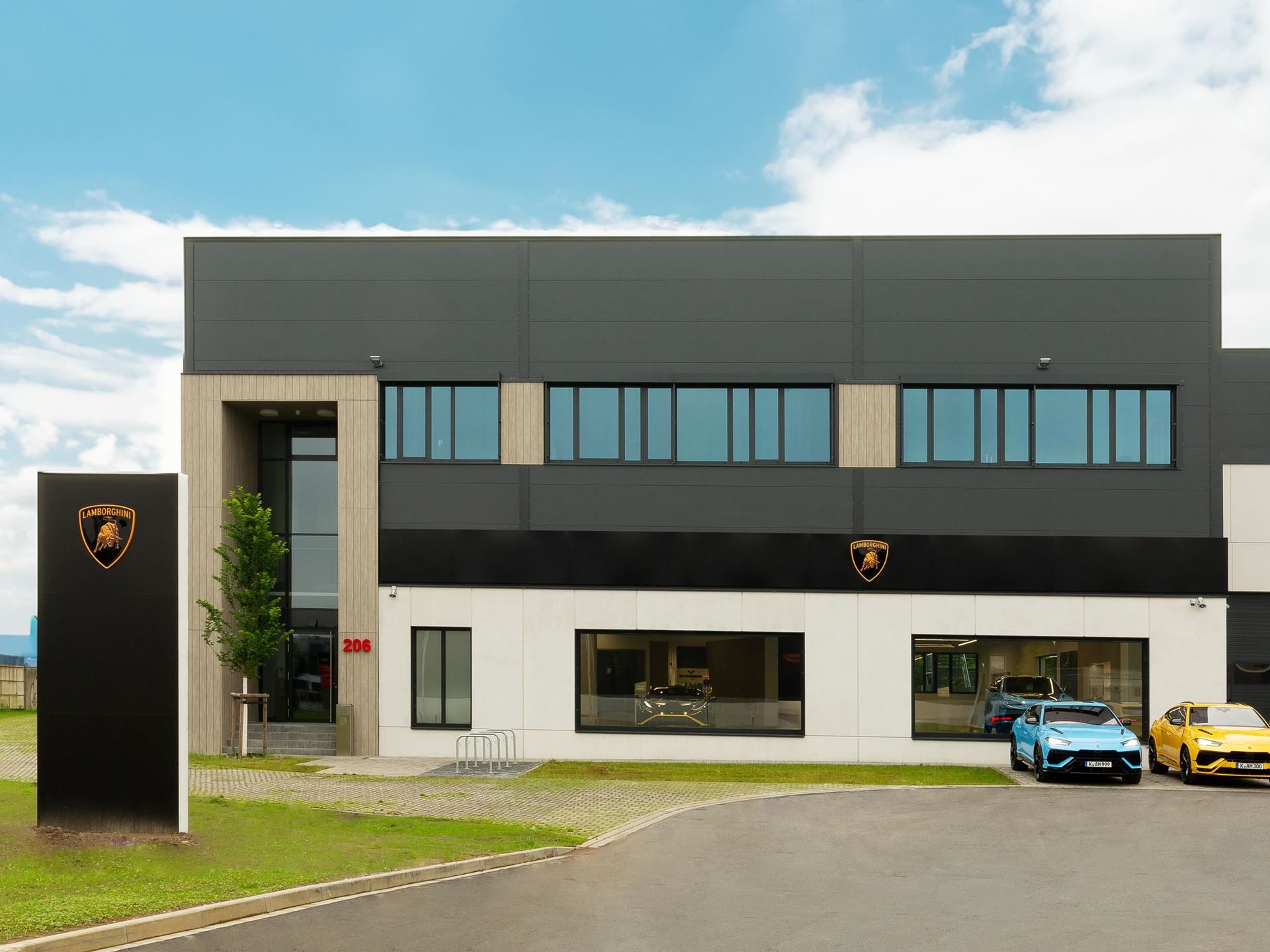 Lamborghini'S New Cologne Showroom Puts The Urus Se Center Stage For Germany'S Hybrid Era 7 Exterior of the new lamborghini cologne dealership building with prominent branding and a blue and yellow urus parked outside