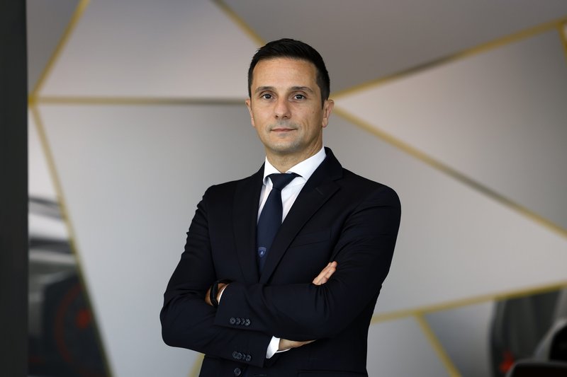 Paolo Gabrielli, new Chief Procurement Officer at Automobili Lamborghini, standing with arms crossed against a modern geometric background