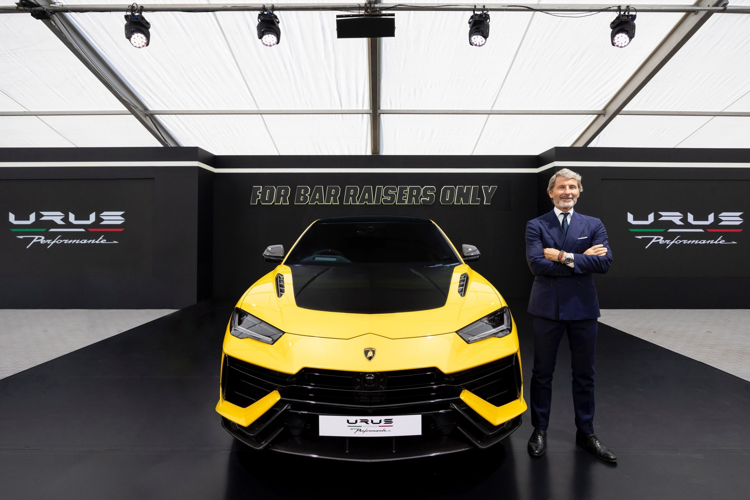 180 Lamborghinis Took Over Tokyo: What Lamborghini Day Japan 2022 Reveals About The Brand'S Asian Strategy 7 Yellow lamborghini urus performante on display at indoor event with 'for bar raisers only' branding